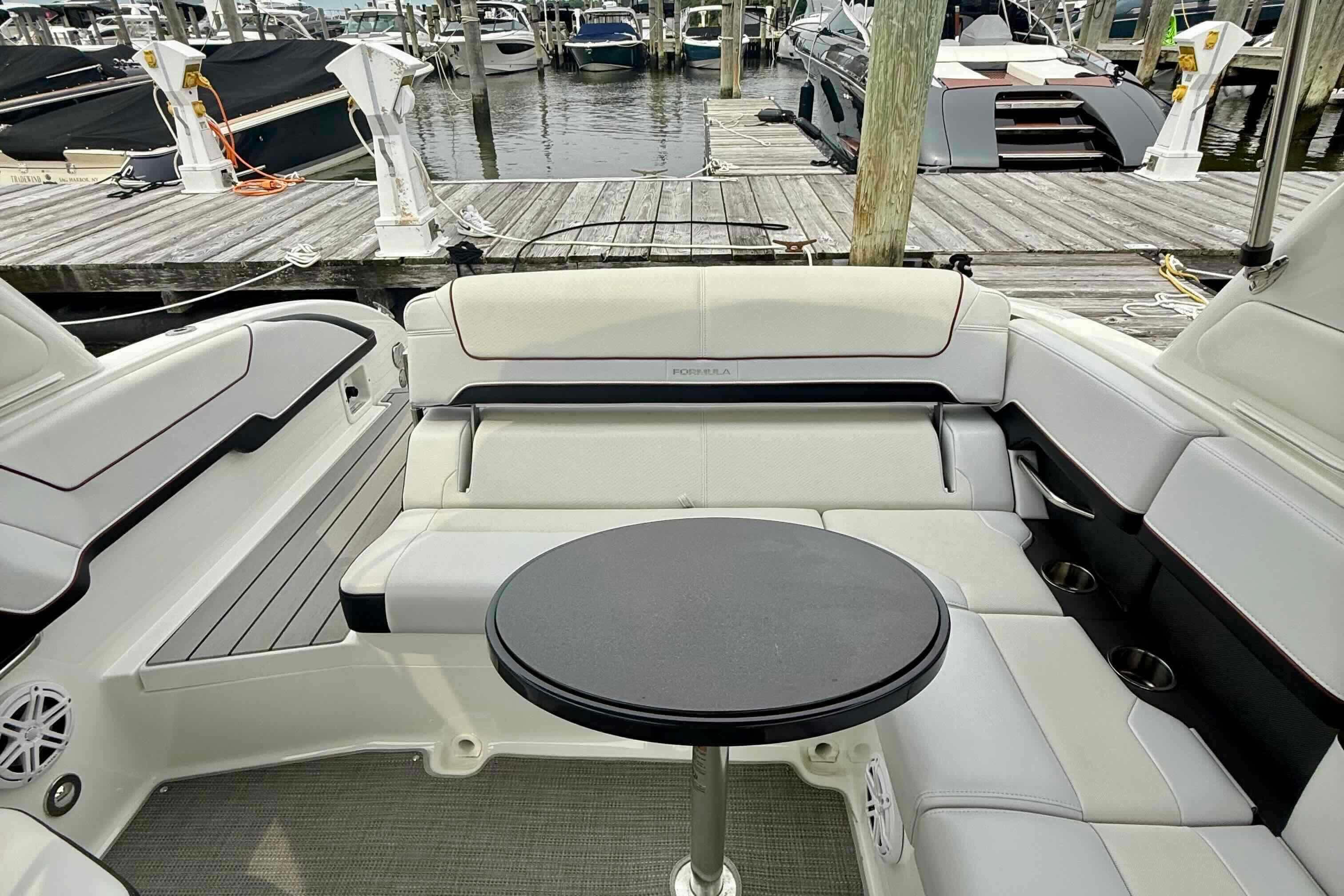 2020 Formula 290 Bowrider interior with white seating and round table at marina.