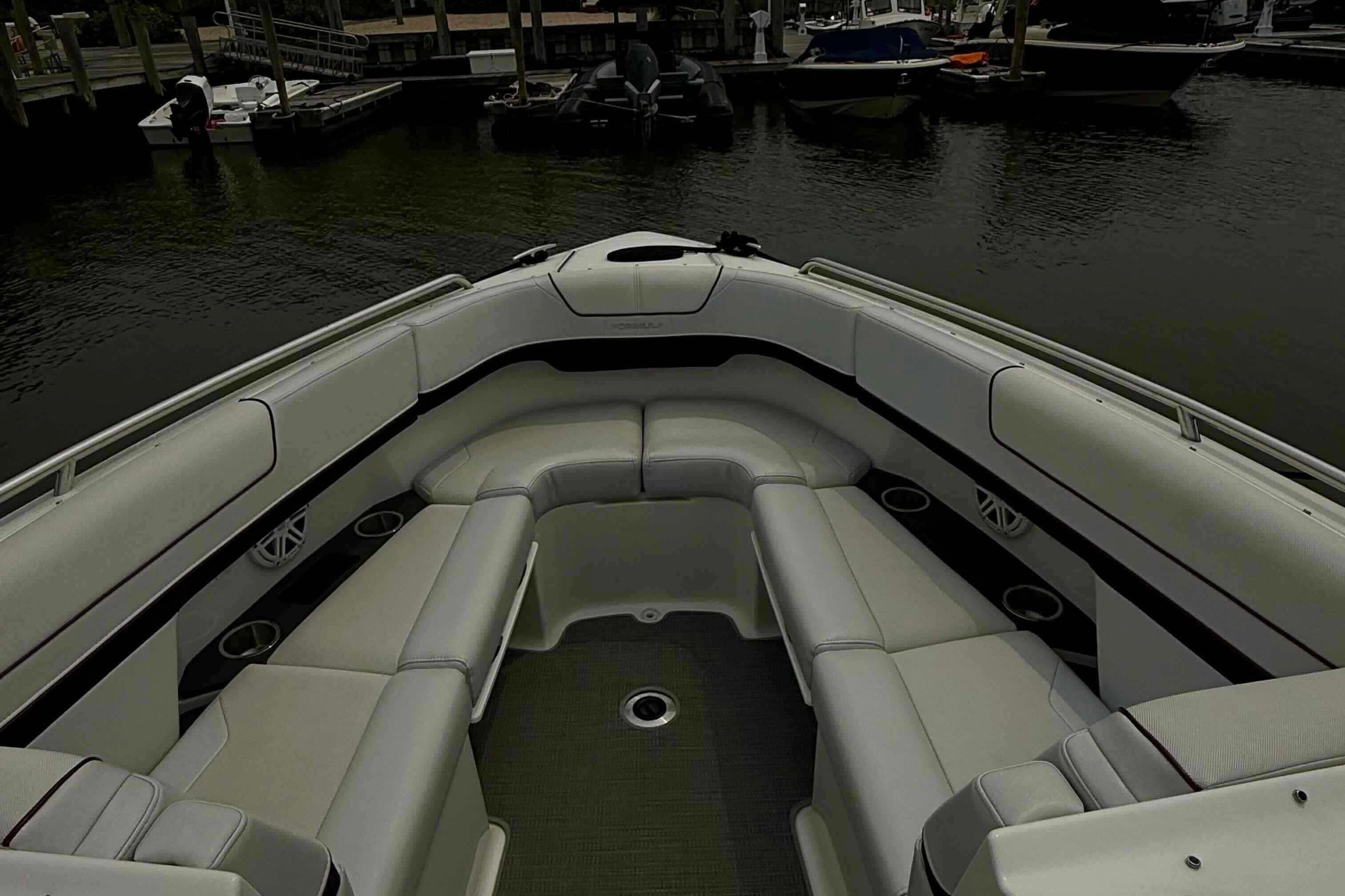 2020 Formula 290 Bowrider boat interior with spacious seating at a marina.