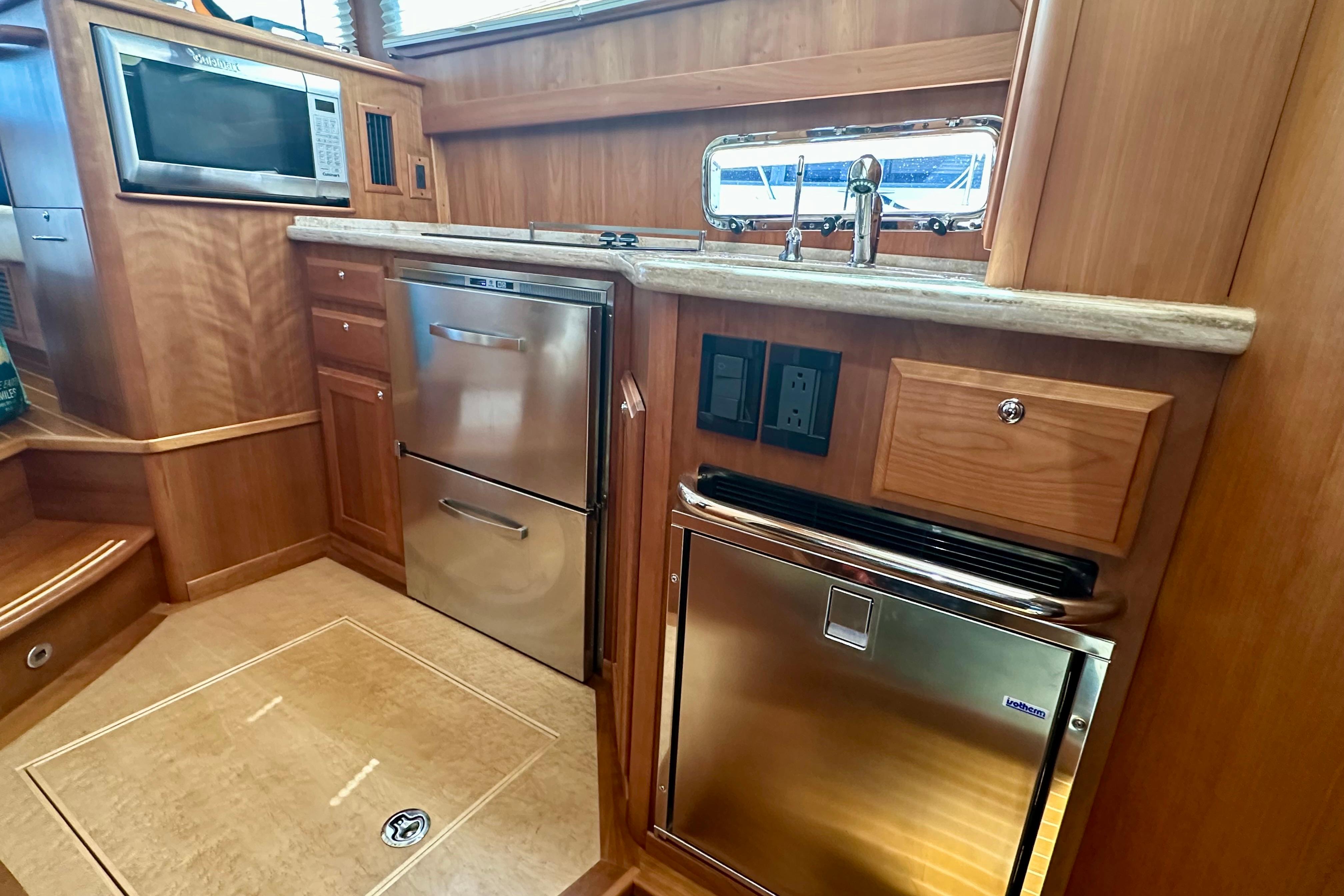 2017 Sabre 42 Salon Express galley with stainless steel appliances and wood cabinetry.