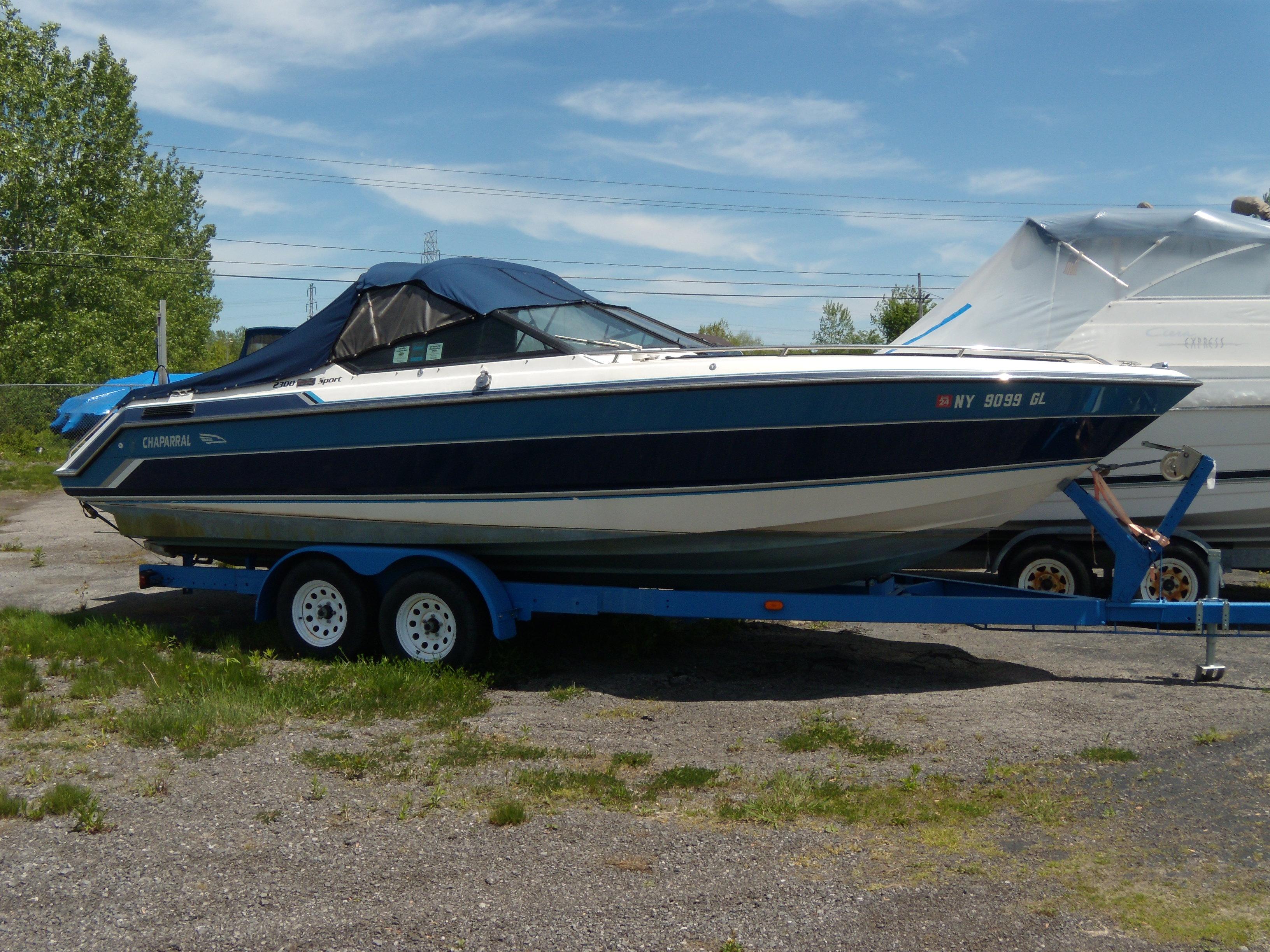 1989 Chaparral 2300 SX Sport boat on trailer, parked outdoors.