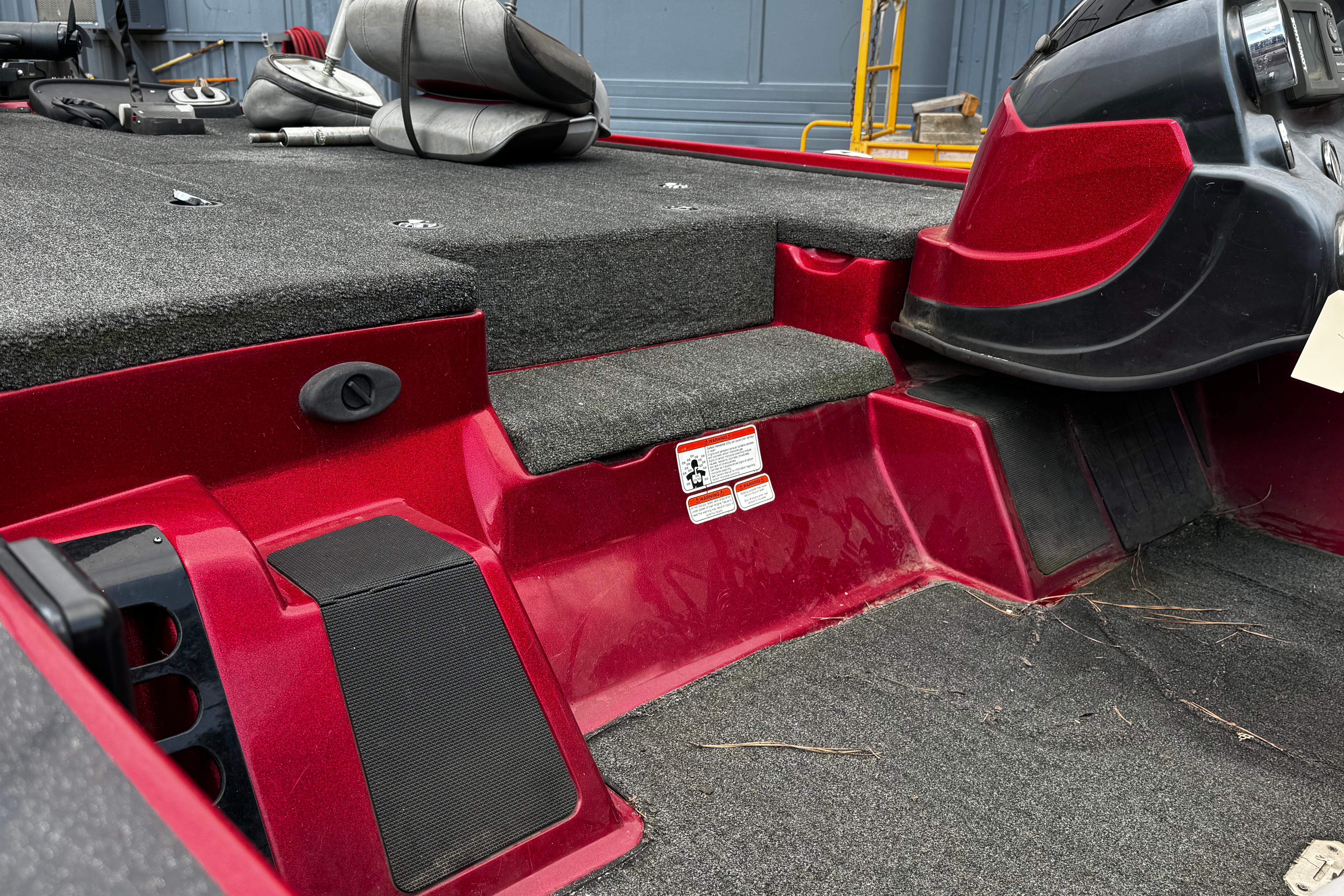 Red 2011 Nitro Z7 boat interior with carpeted deck and seating area.