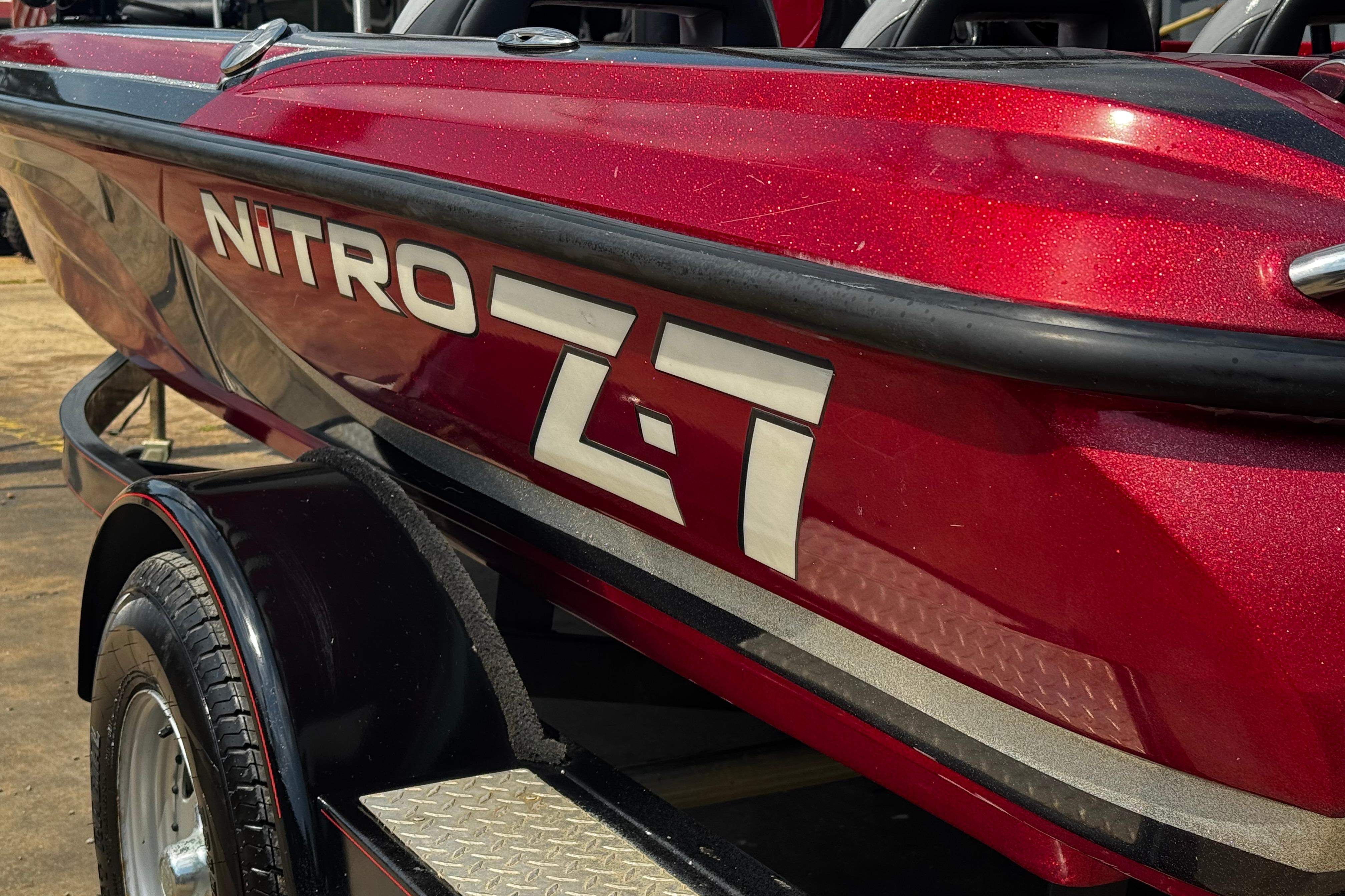 Red 2011 Nitro Z7 boat on trailer, close-up view of logo and design.