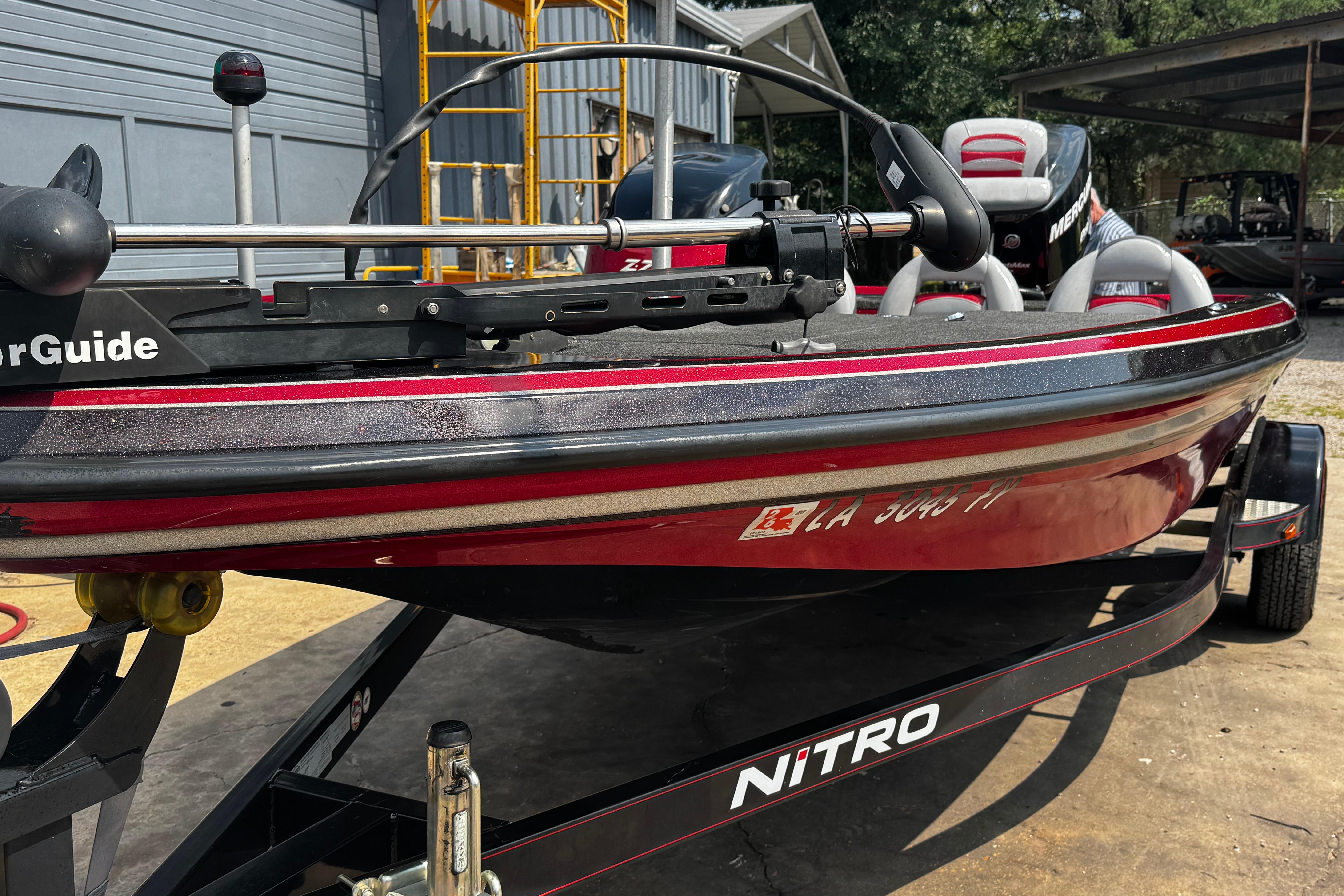 2011 Nitro Z7 boat on trailer, featuring MotorGuide equipment, parked outdoors.
