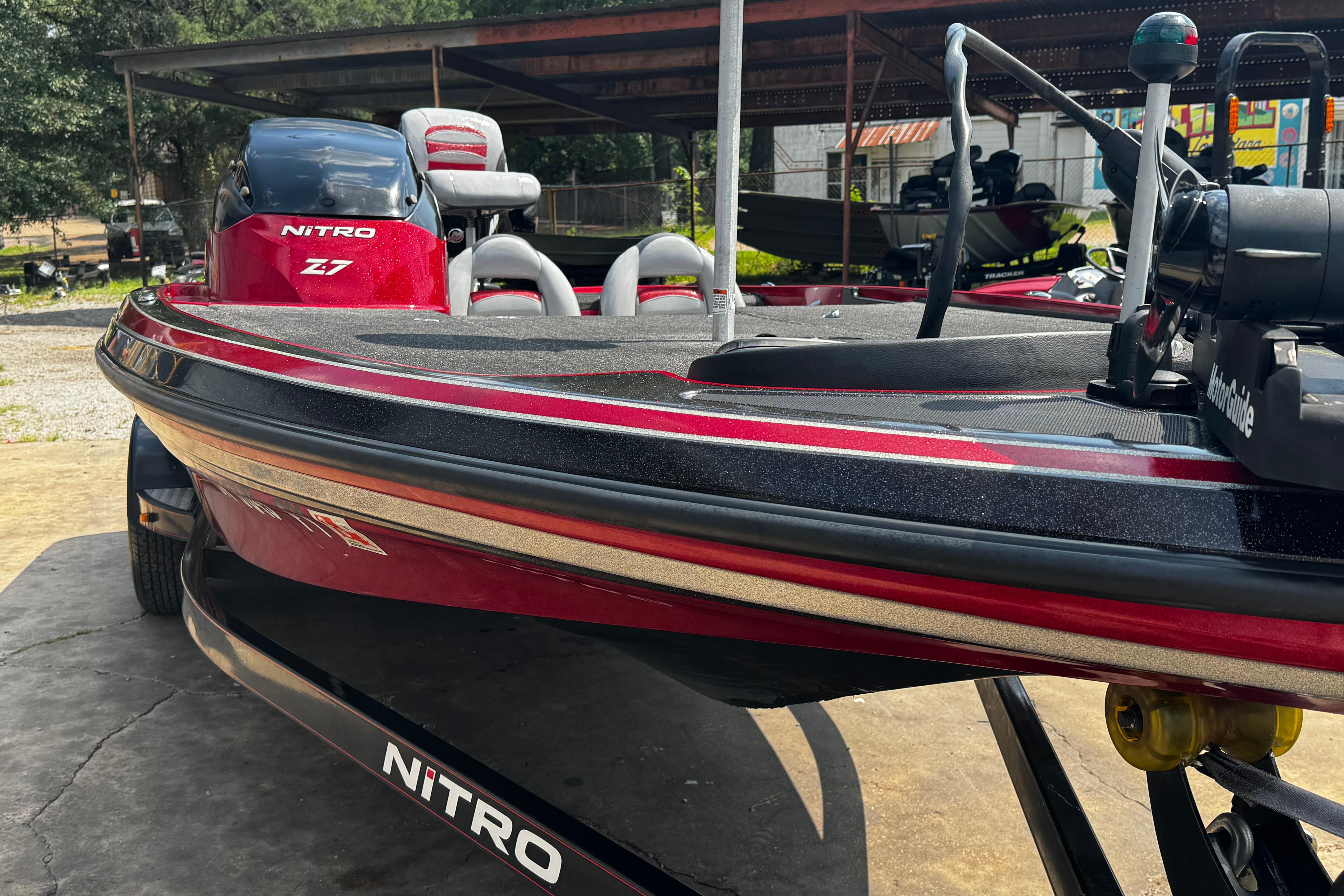 2011 Nitro Z7 boat in red and black, parked under a shelter.