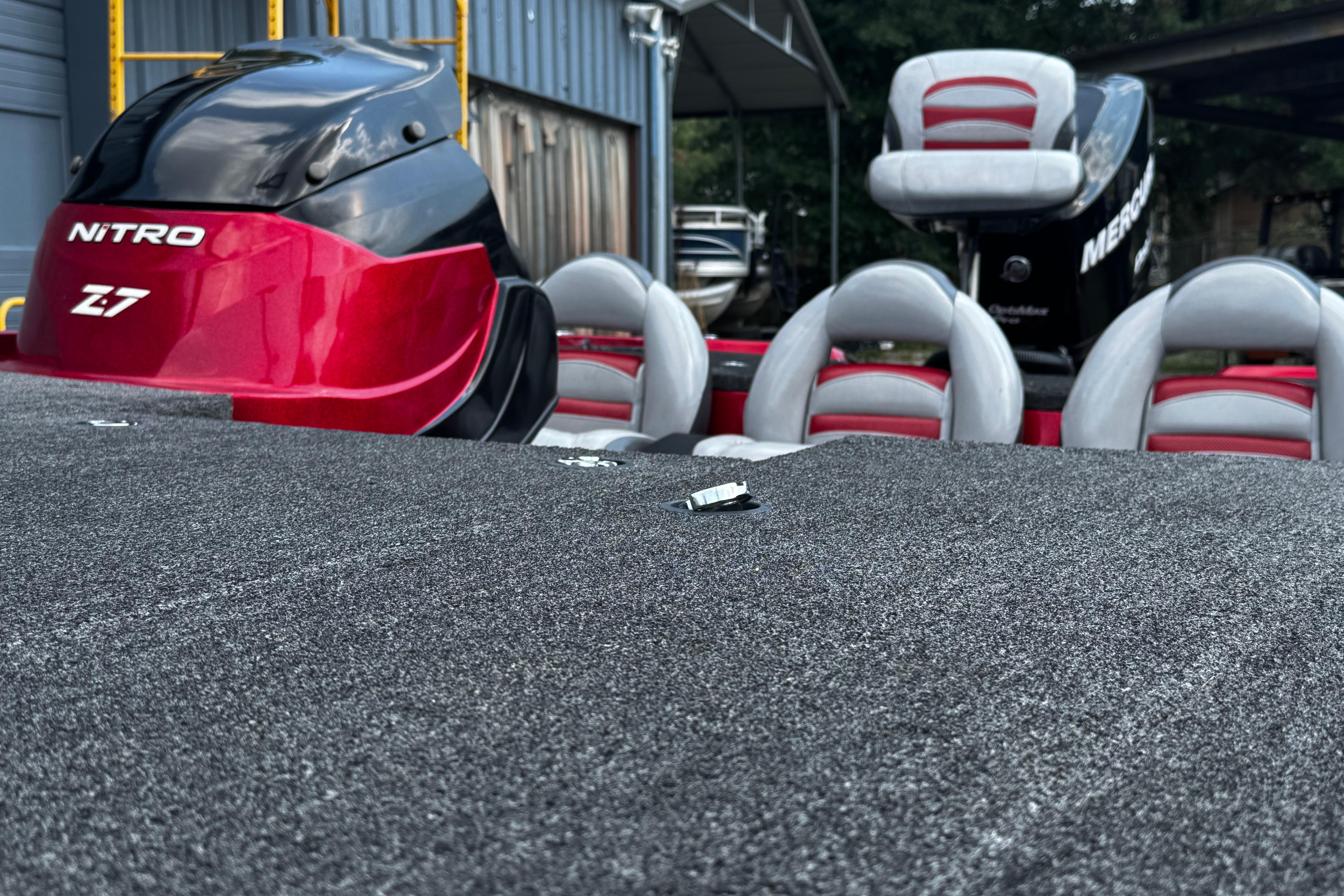 2011 Nitro Z7 boat with red and black motor, gray seating, outdoor setting.