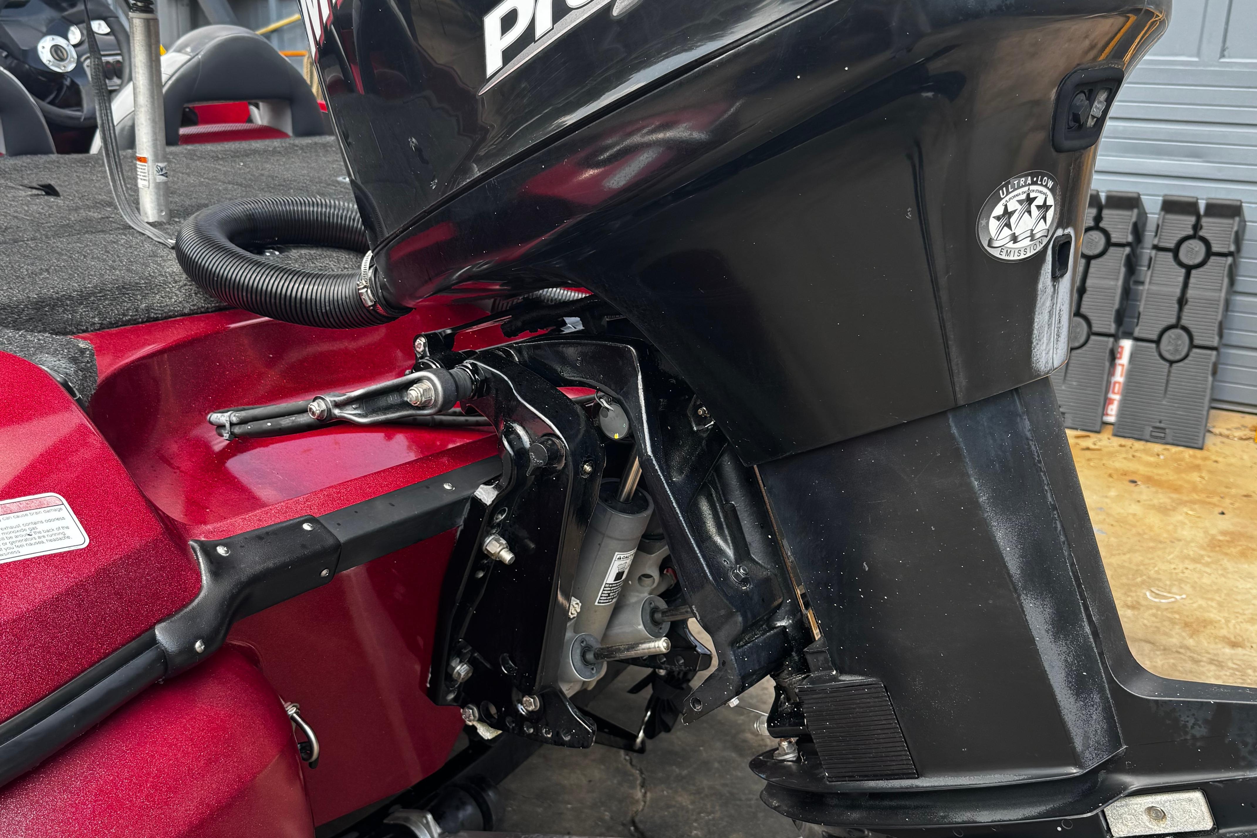 2011 Nitro Z7 boat with black outboard motor, red hull, and ultra-low emission sticker.