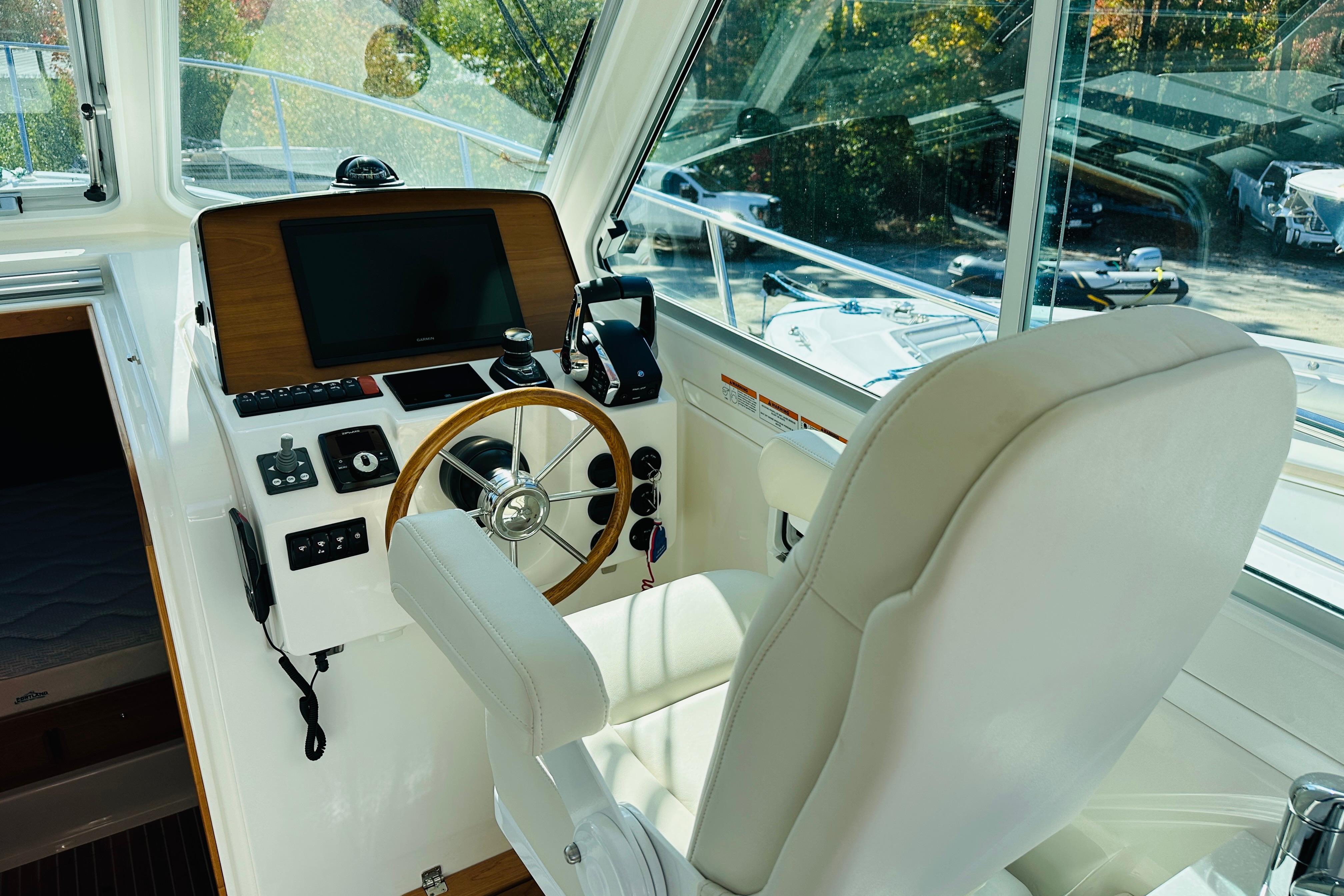 2024 Back Cove 34O helm with steering wheel, controls, and navigation screen.