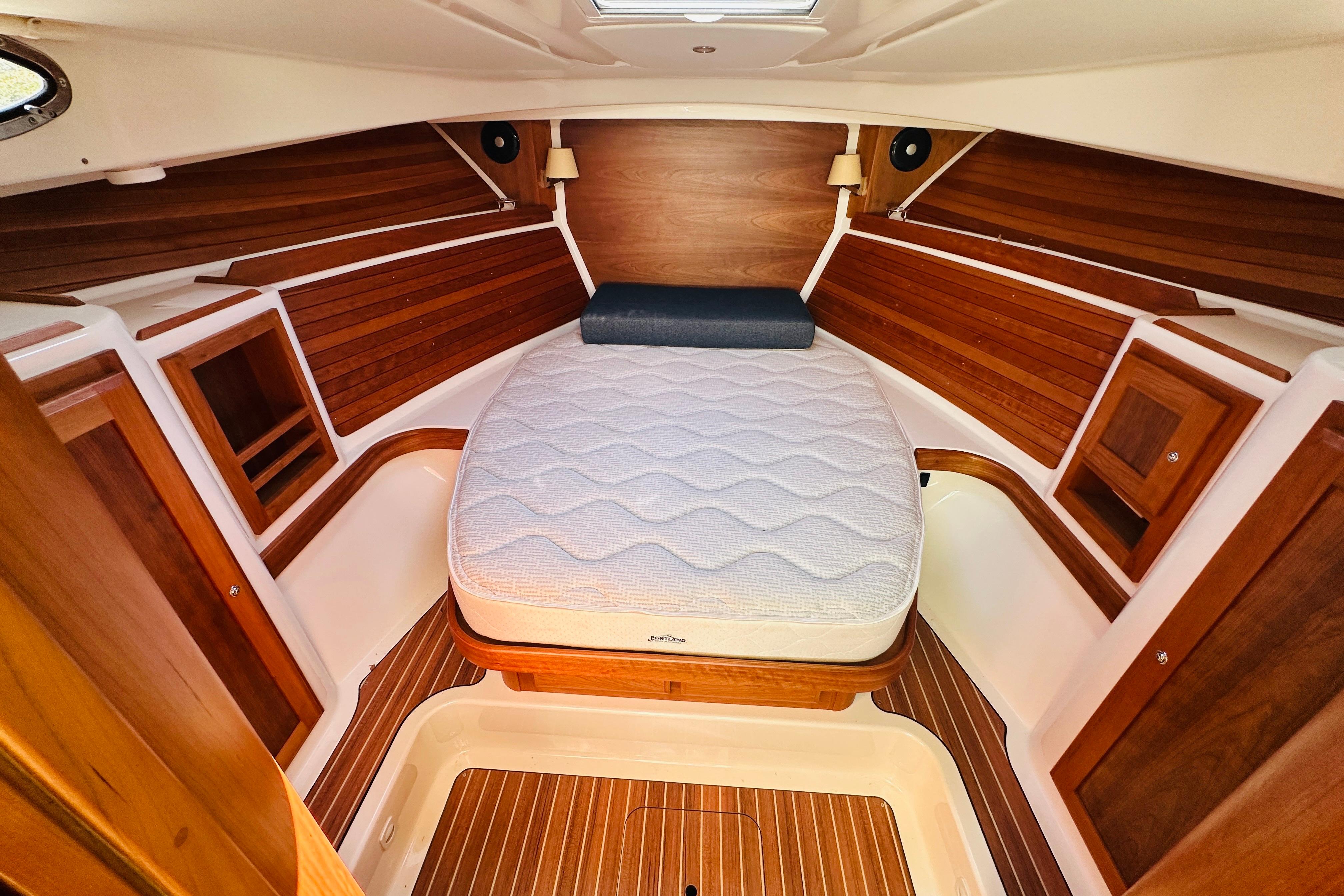 2024 Back Cove 34O cabin interior with wooden finish and comfortable bedding.