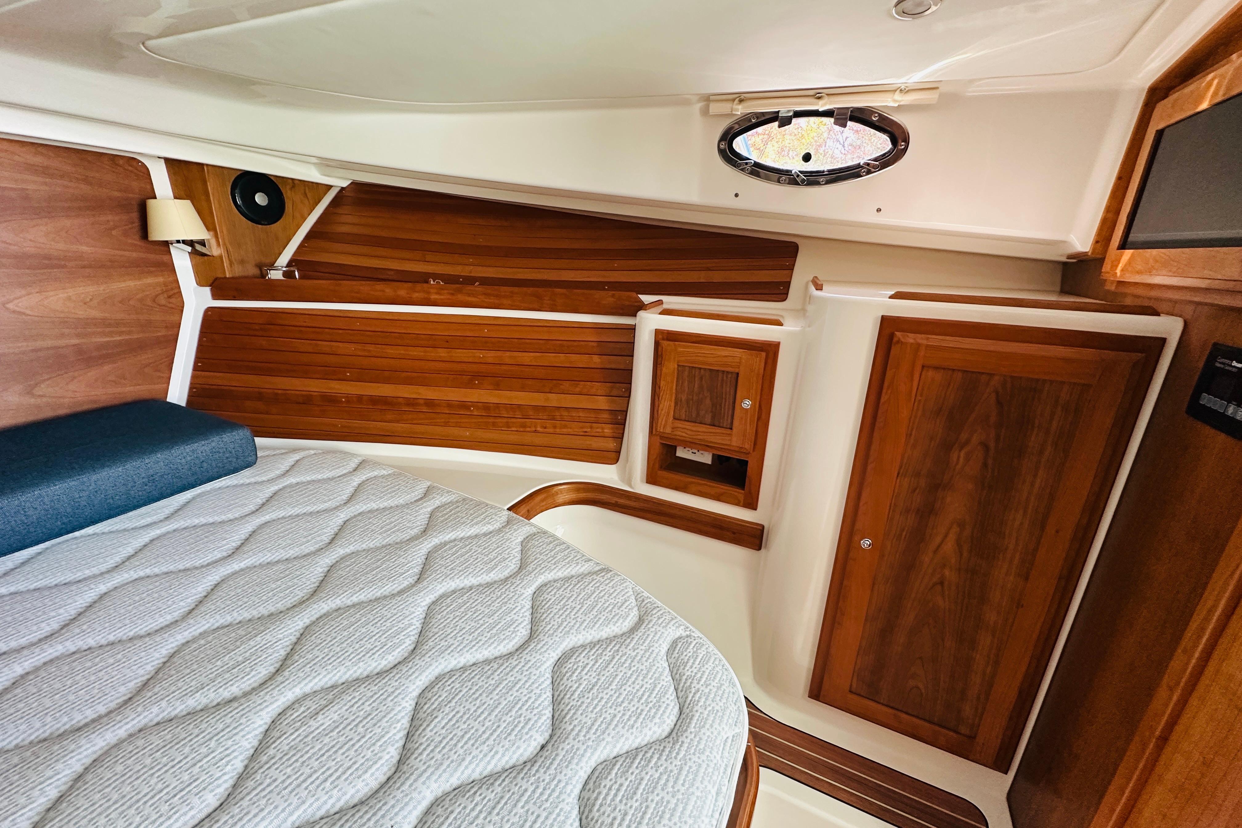 2024 Back Cove 34O cabin interior with wood paneling and comfortable bedding.