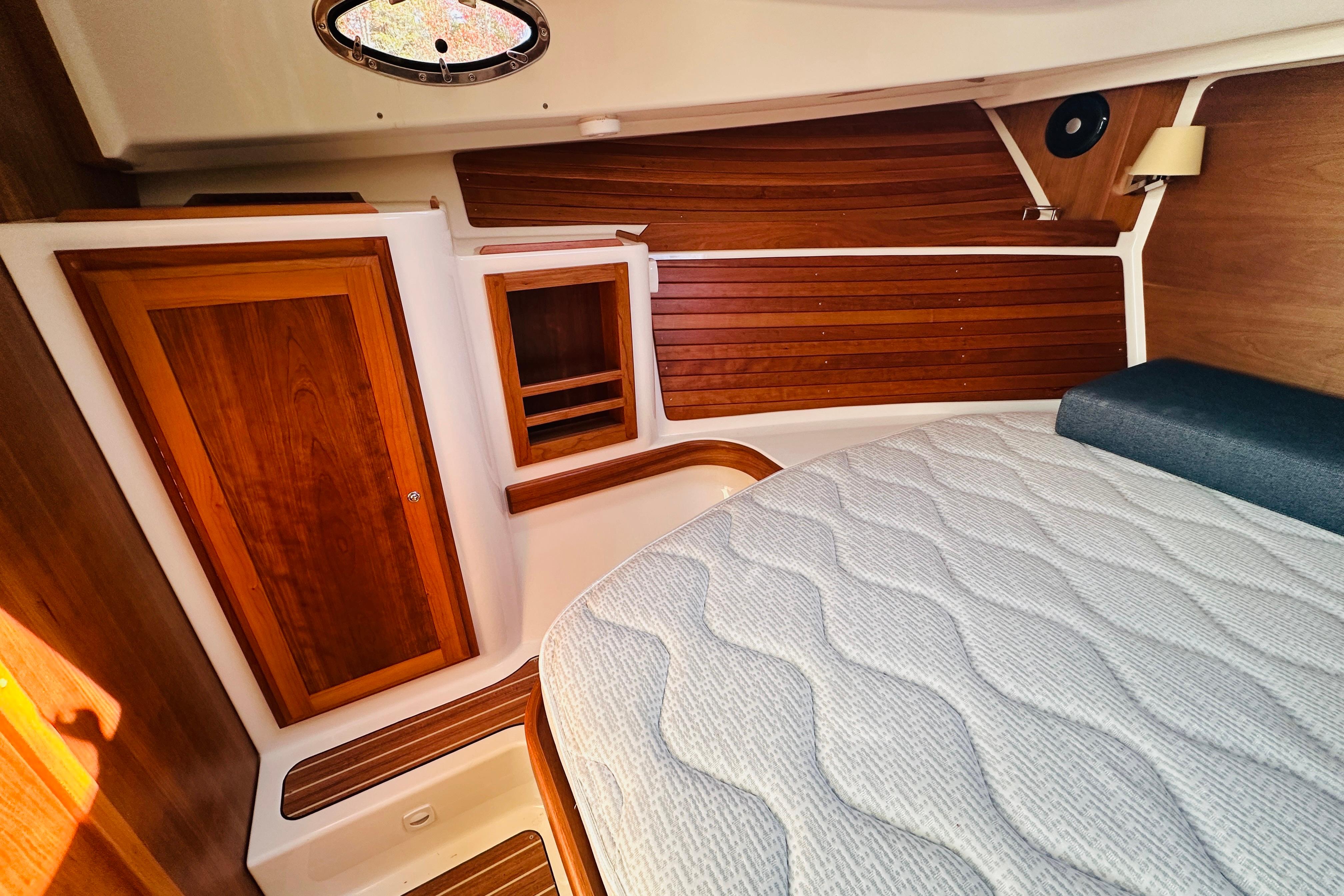 2024 Back Cove 34O cabin interior with wooden accents and a comfortable bed.