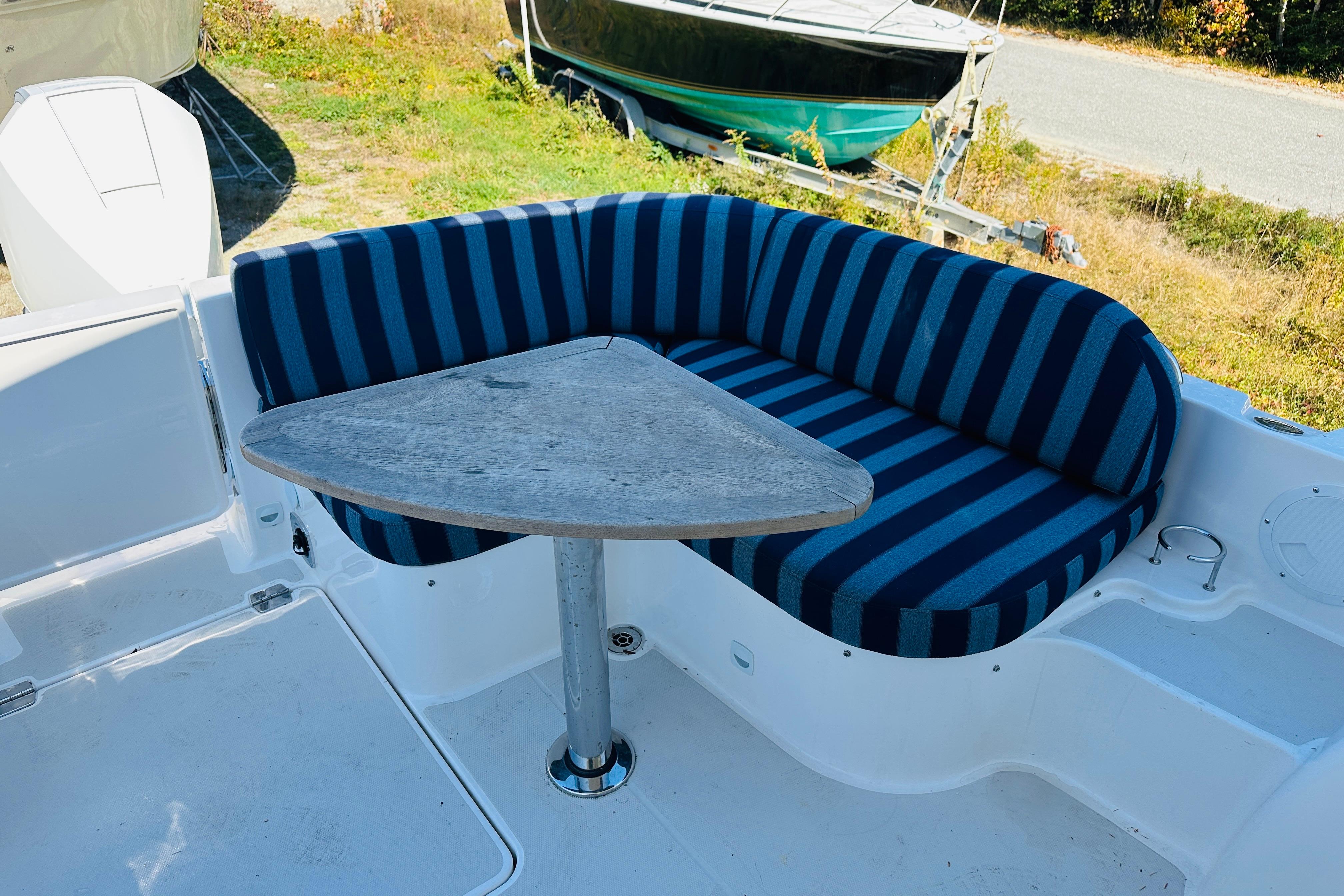 2024 Back Cove 34O boat with striped seating and triangular table on deck.