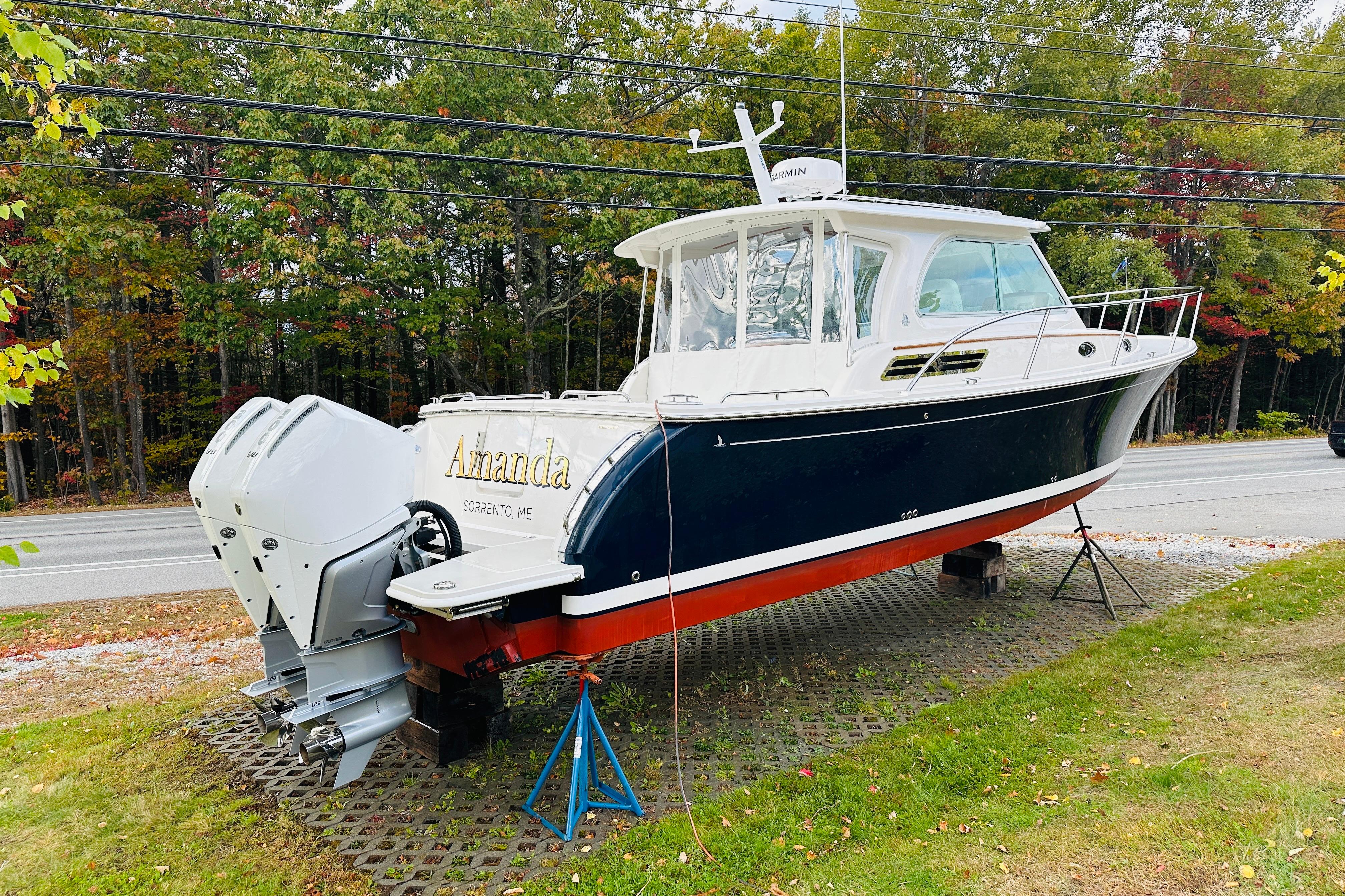 2024 Back Cove 34O boat on display, featuring dual outboard engines, parked roadside.