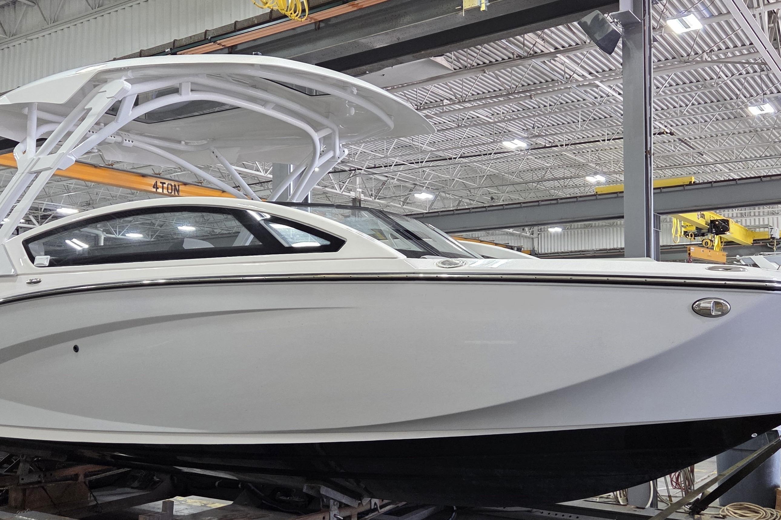2023 Yamaha Boats 275SDX in a showroom, showcasing sleek design and modern features.