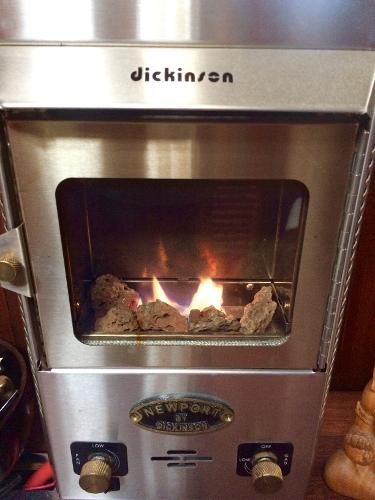 Dickinson Newport stove with visible flames, installed on a 1971 Formosa 41 boat.