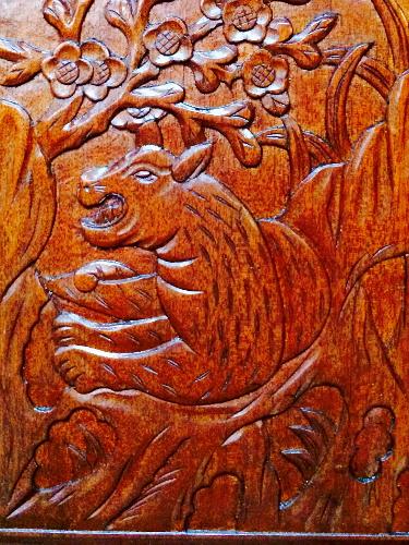 Intricate wooden carving of a tiger and flowers on a Formosa 41, 1971.