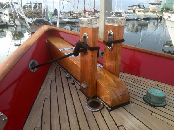 Wooden deck of a 1971 Formosa 41 sailboat with mooring posts in a marina.