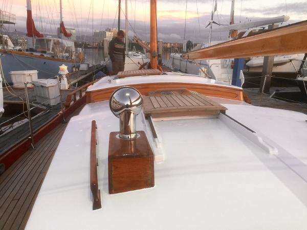 1971 Formosa 41 sailboat deck with wooden details at sunset in a marina.