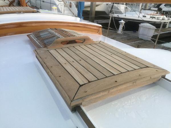 Wooden deck hatch on a 1971 Formosa 41 sailboat, docked at a marina.