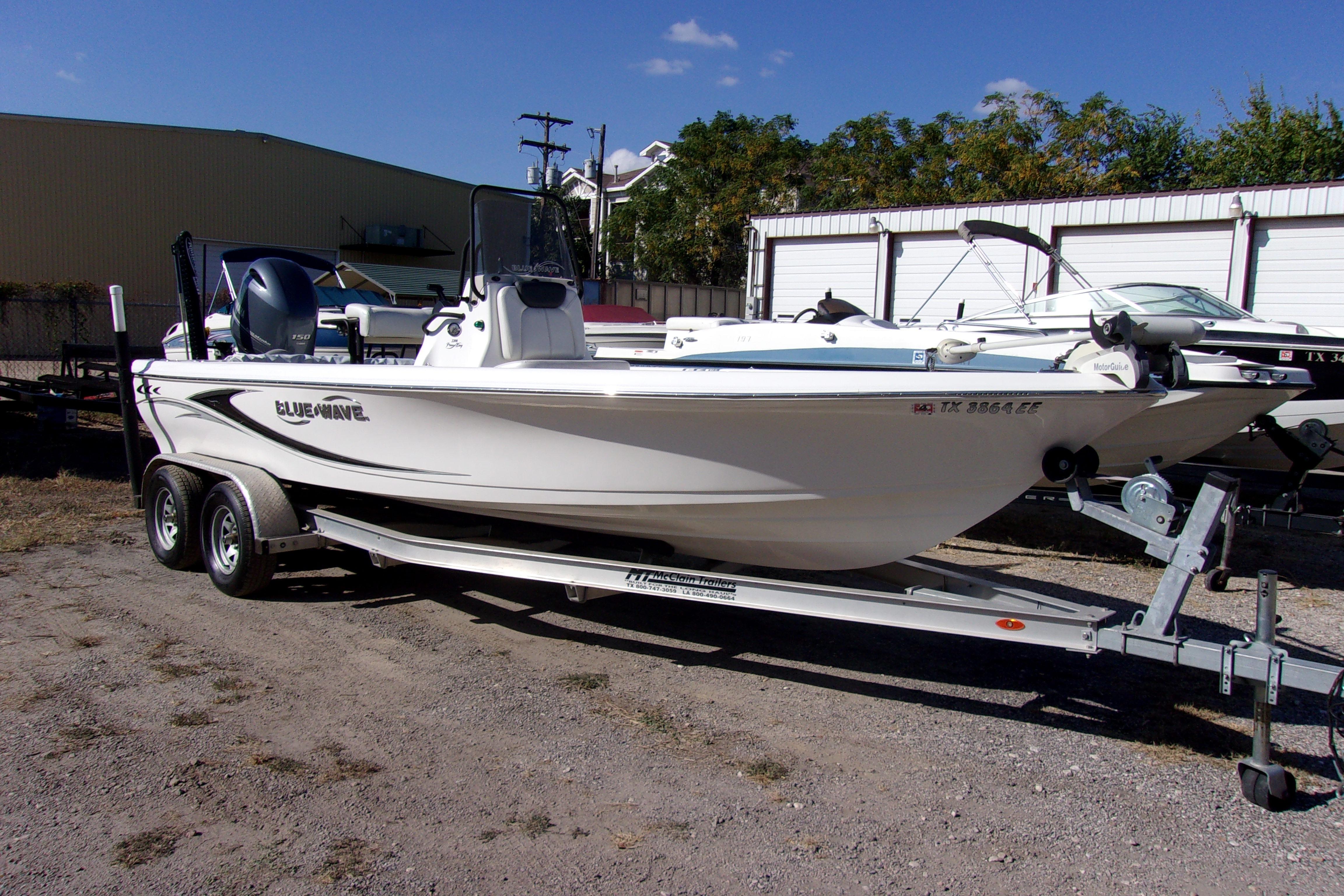 2018 Blue Wave 2200 PureBay boat on trailer, parked outdoors under clear sky.