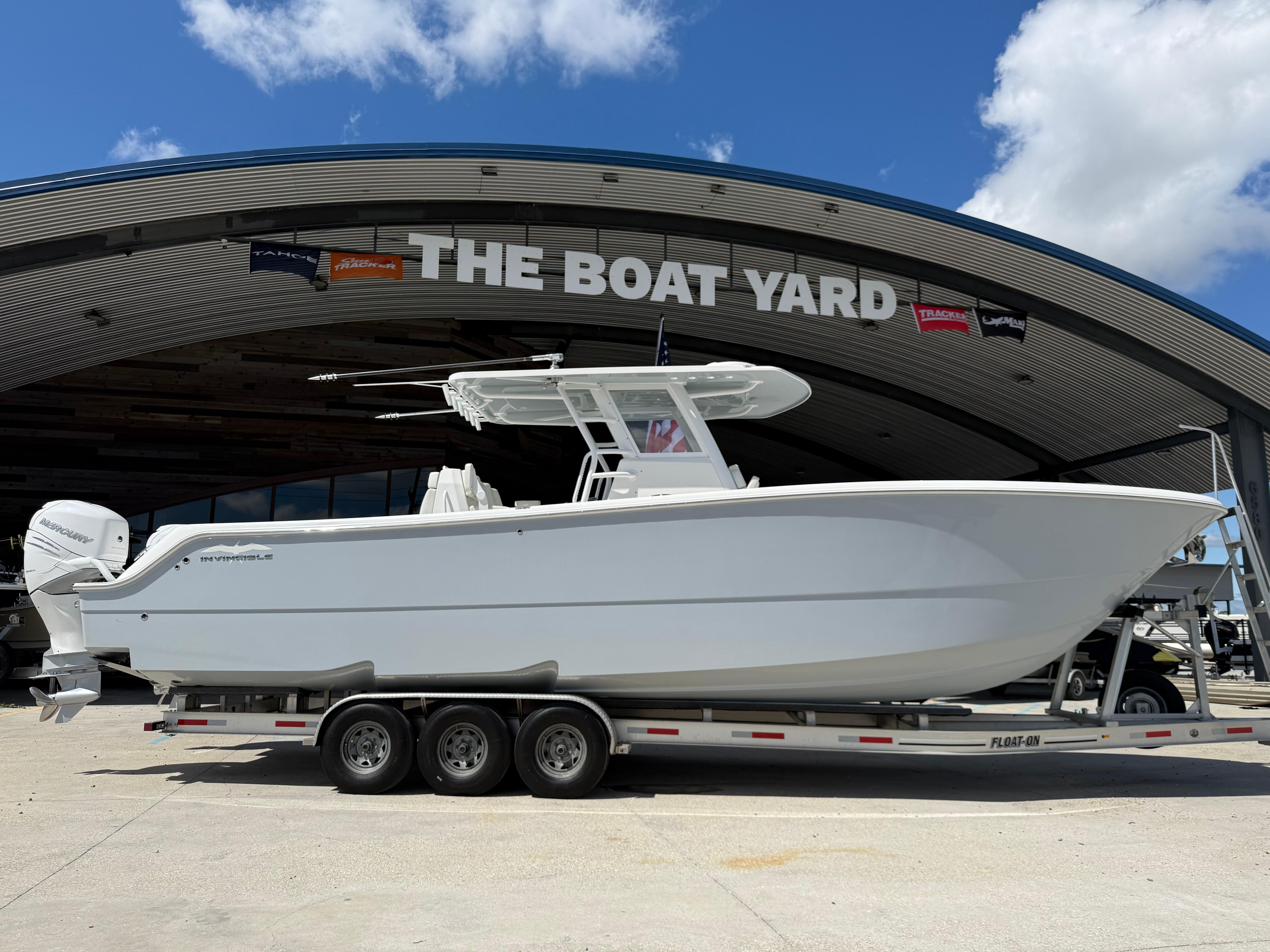 2022 Invincible 33 Catamaran on trailer at The Boat Yard under clear sky.