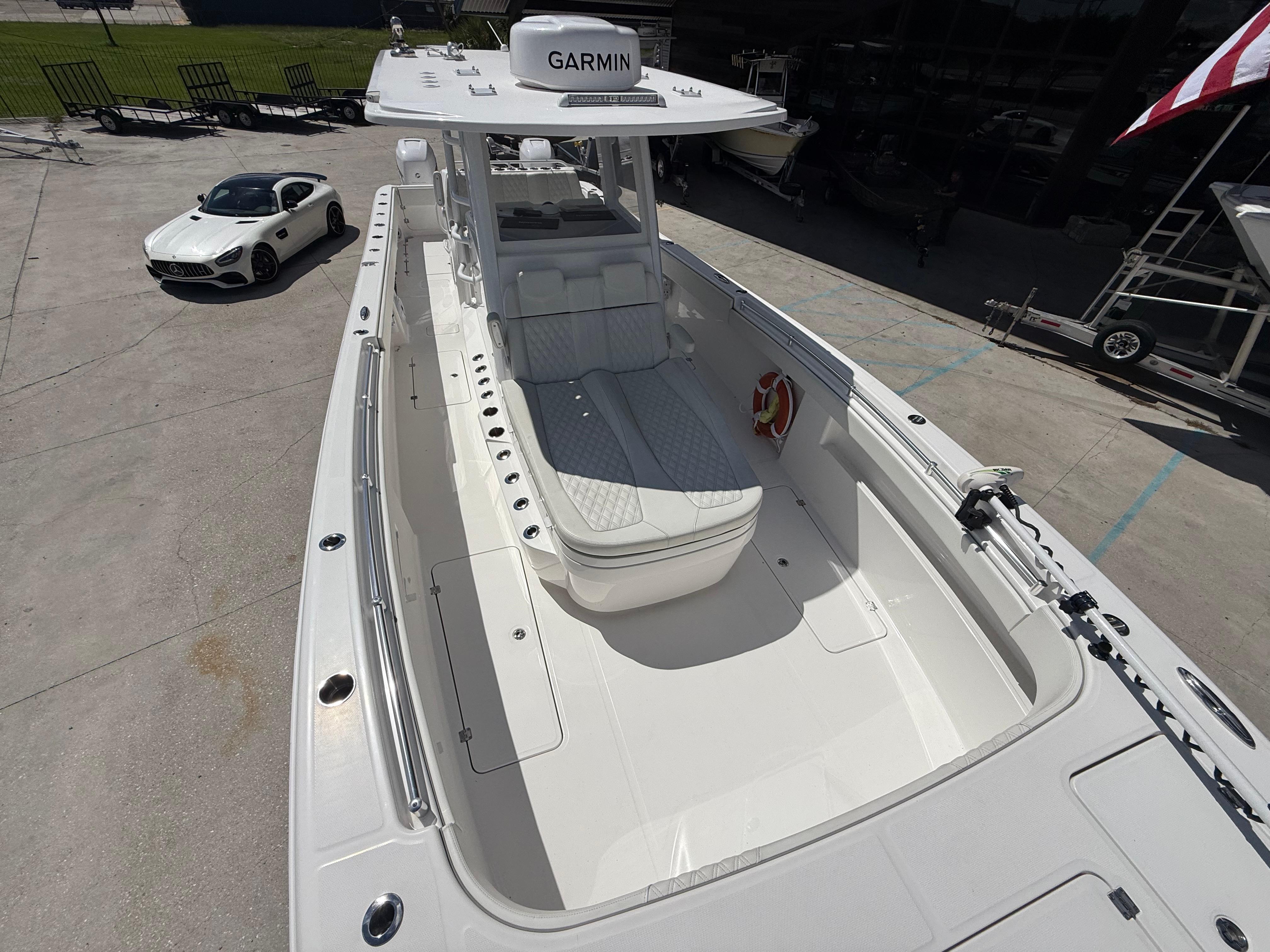 2022 Invincible 33 Catamaran with Garmin equipment, parked near a luxury car.