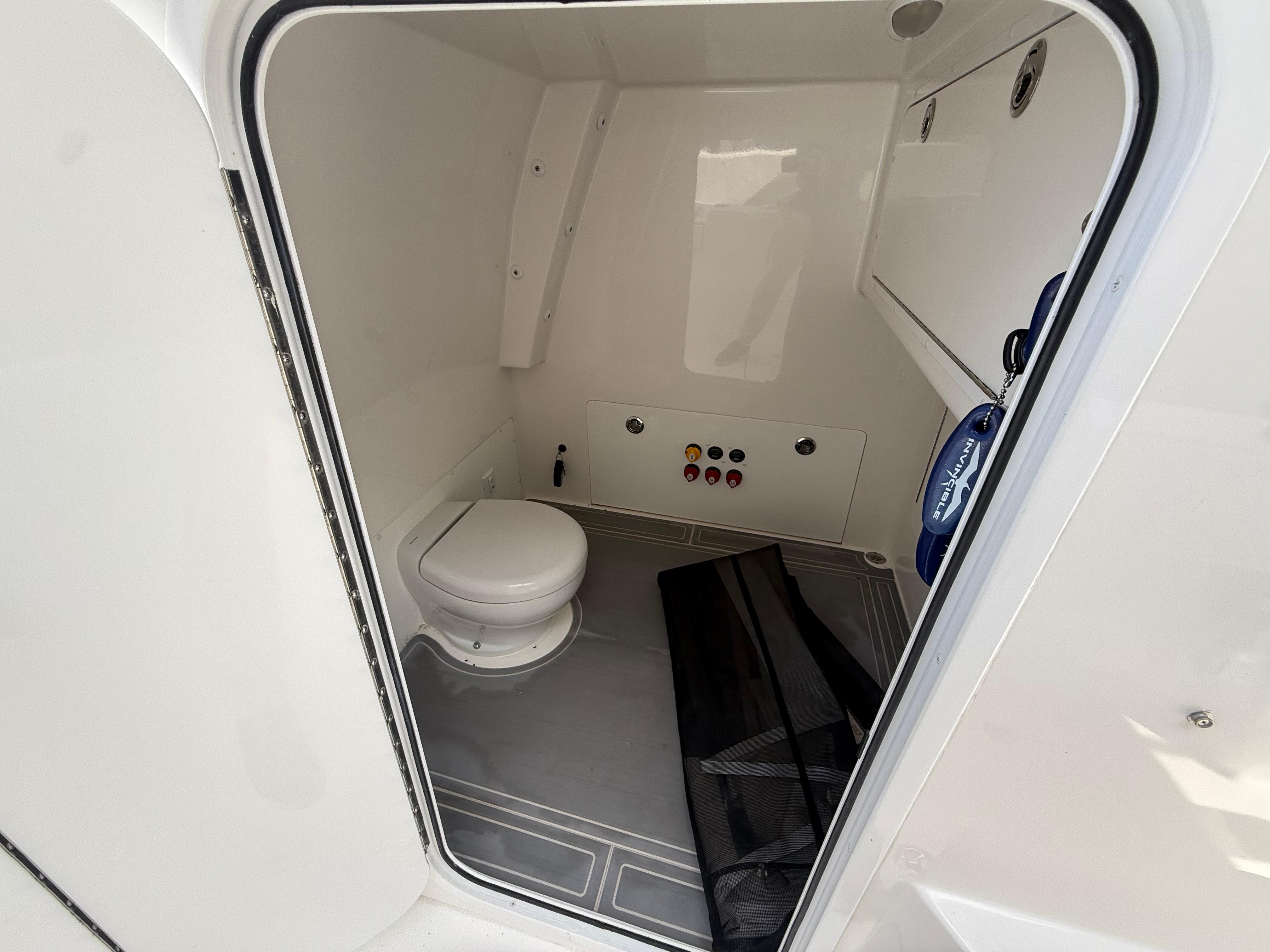 2022 Invincible 33 Catamaran interior bathroom with toilet and control panel.