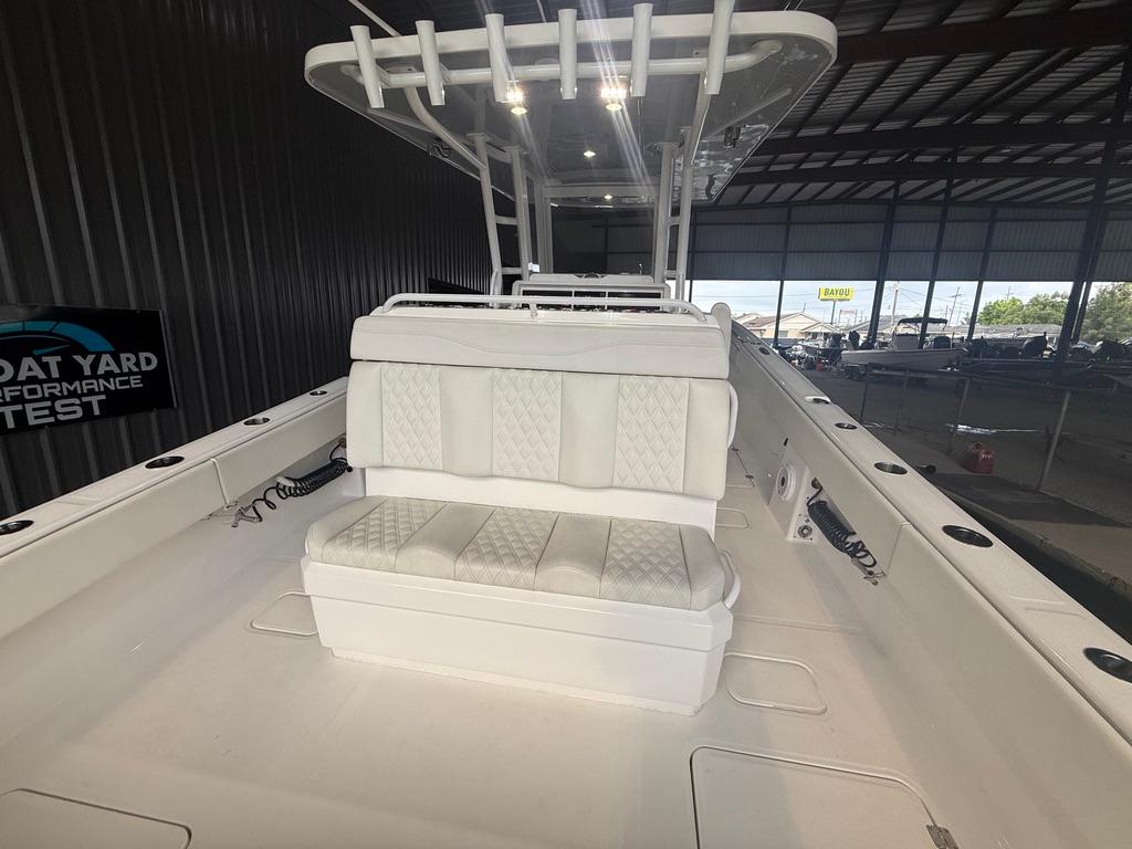 2022 Invincible 33 Catamaran interior with white seating in a boatyard setting.