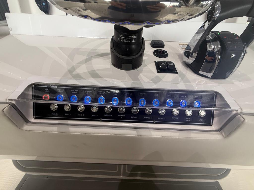 Control panel of 2022 Invincible 33 Catamaran with illuminated switches and throttle lever.