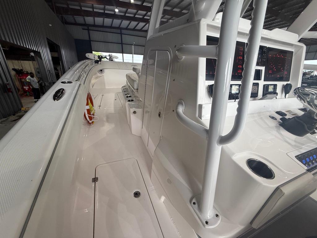 2022 Invincible 33 Catamaran interior with modern controls and spacious deck in a warehouse setting.