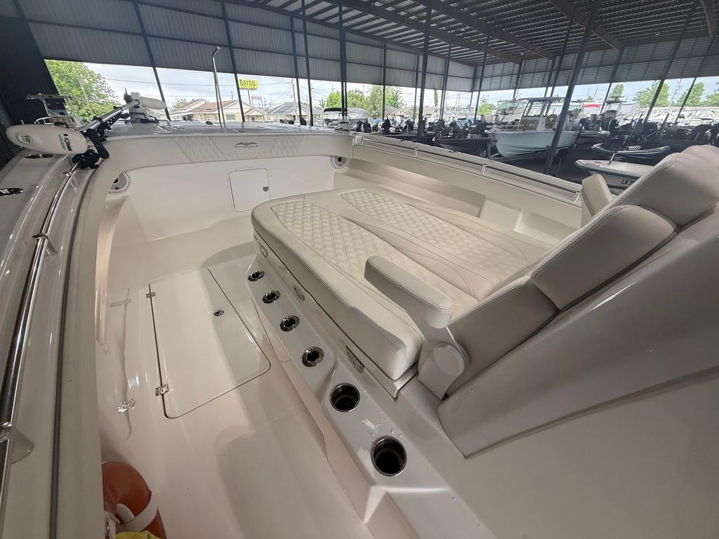 2022 Invincible 33 Catamaran interior with cushioned seating and rod holders in a covered marina.