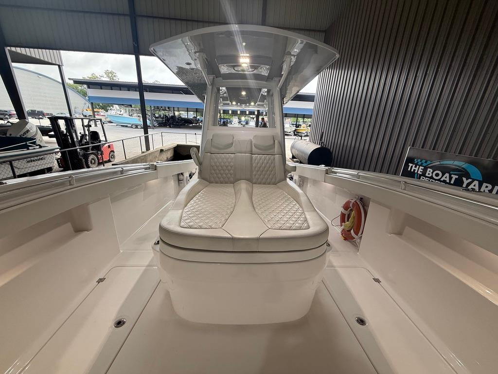2022 Invincible 33 Catamaran interior with cushioned seating, docked at a marina.