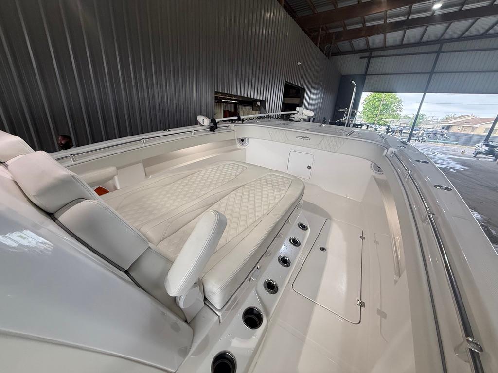 2022 Invincible 33 Catamaran interior with cushioned seating in a spacious boat garage.