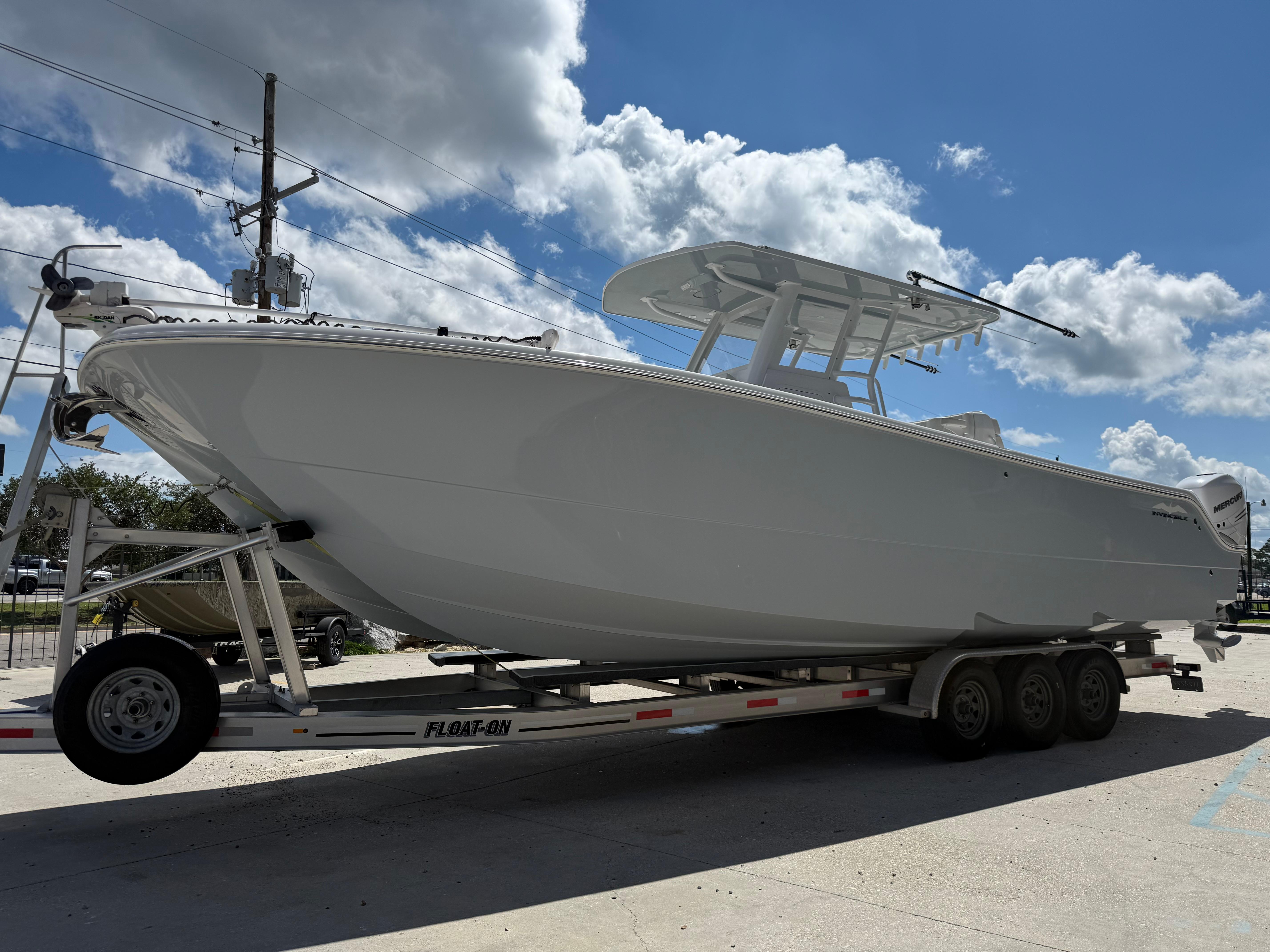 2022 Invincible 33 Catamaran on trailer under blue sky with clouds.
