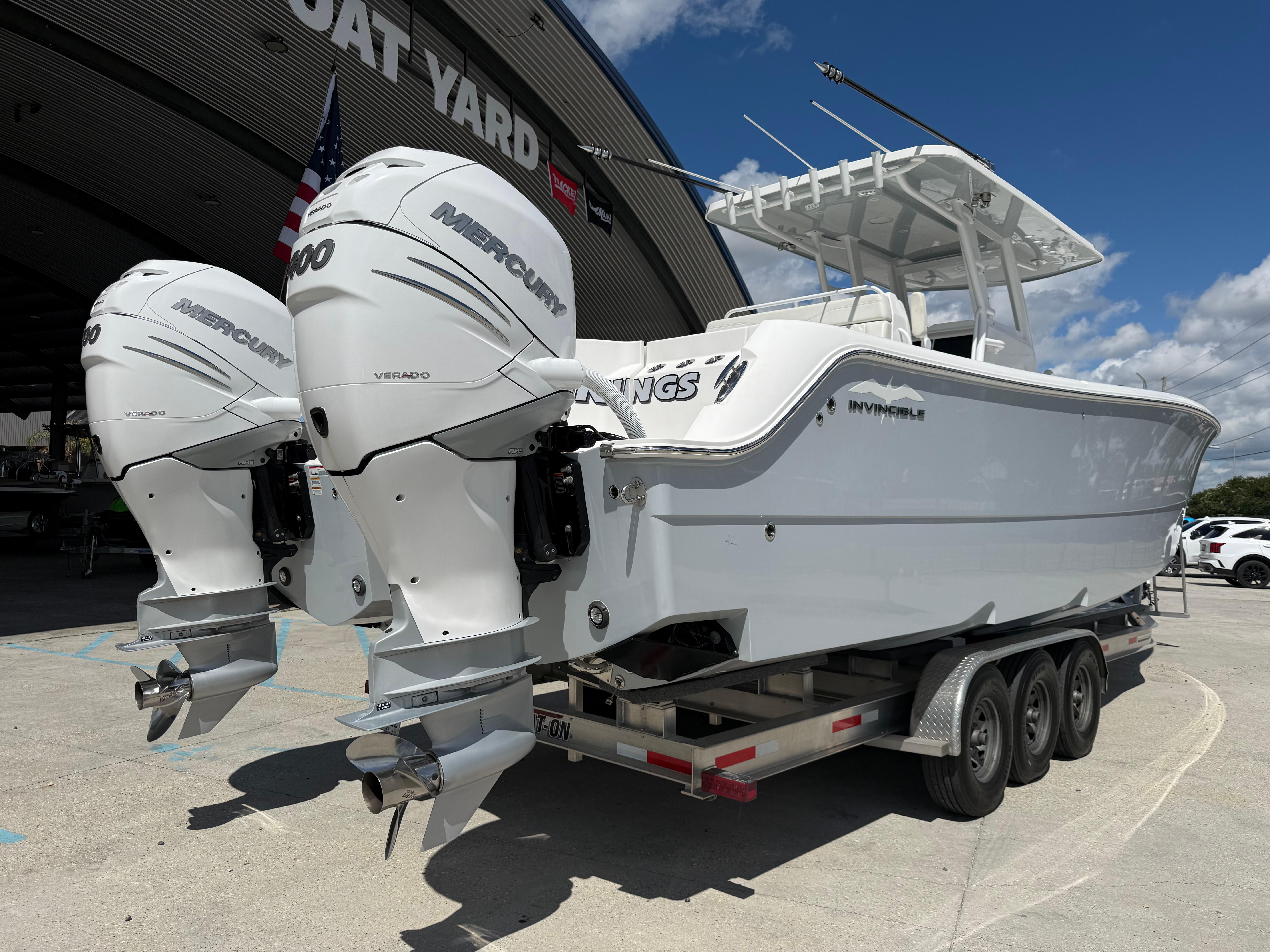 2022 Invincible 33 Catamaran with twin Mercury engines on a trailer at a boat yard.
