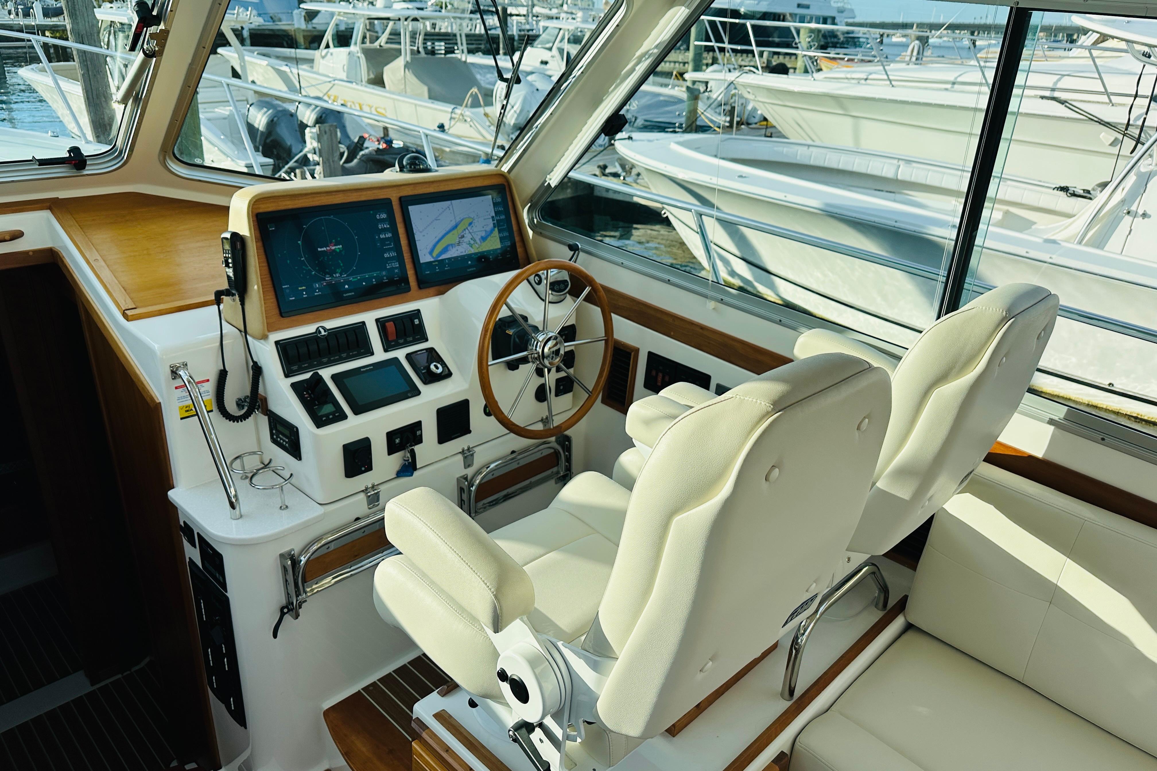 Interior of 2020 Back Cove 37 yacht cockpit with navigation screens and plush seating.