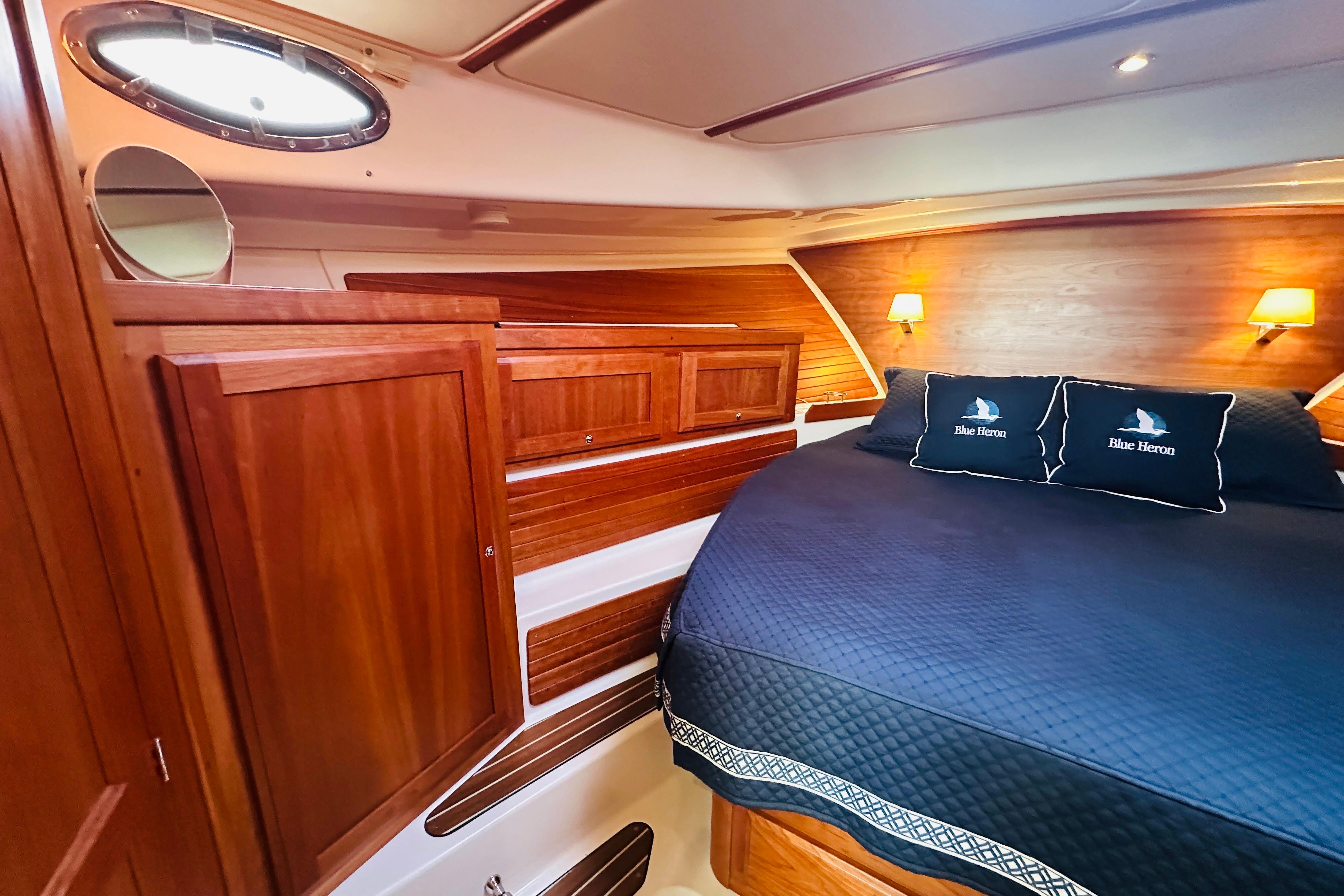 Luxurious cabin interior of 2020 Back Cove 37 yacht with wood paneling and cozy bedding.