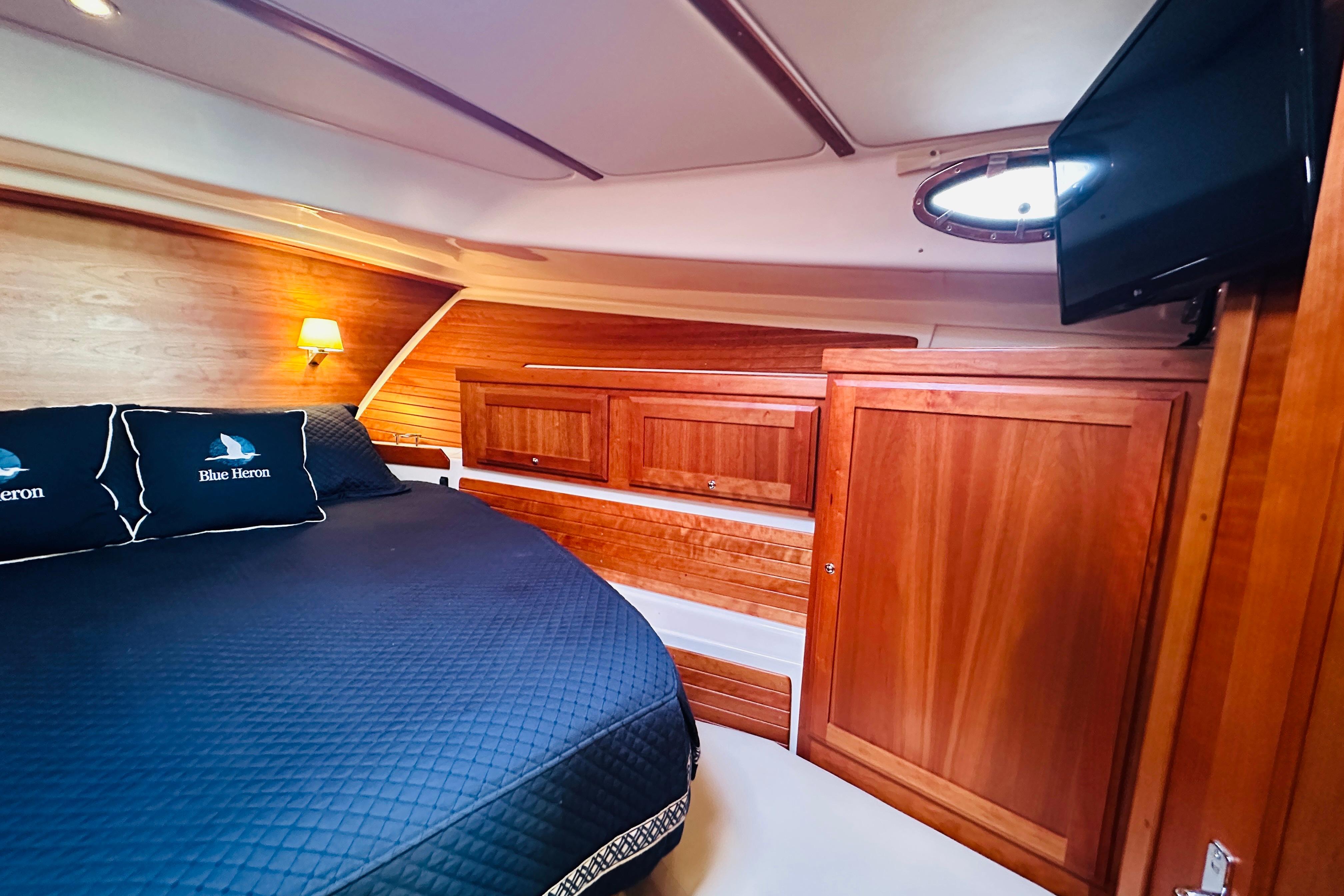 Luxurious cabin interior of 2020 Back Cove 37 yacht with wood finish and cozy bedding.