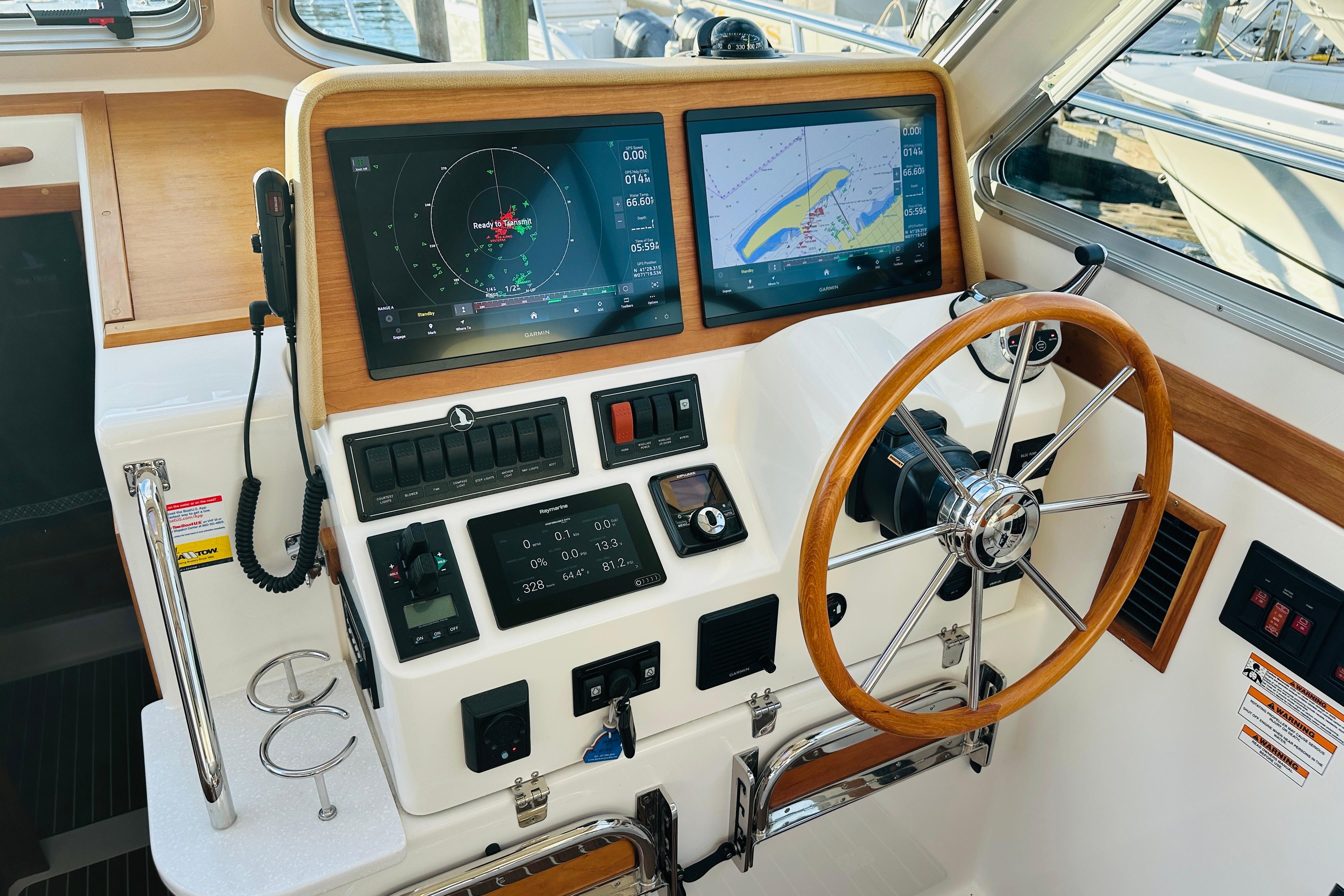 Helm of 2020 Back Cove 37 boat with navigation screens and wooden steering wheel.