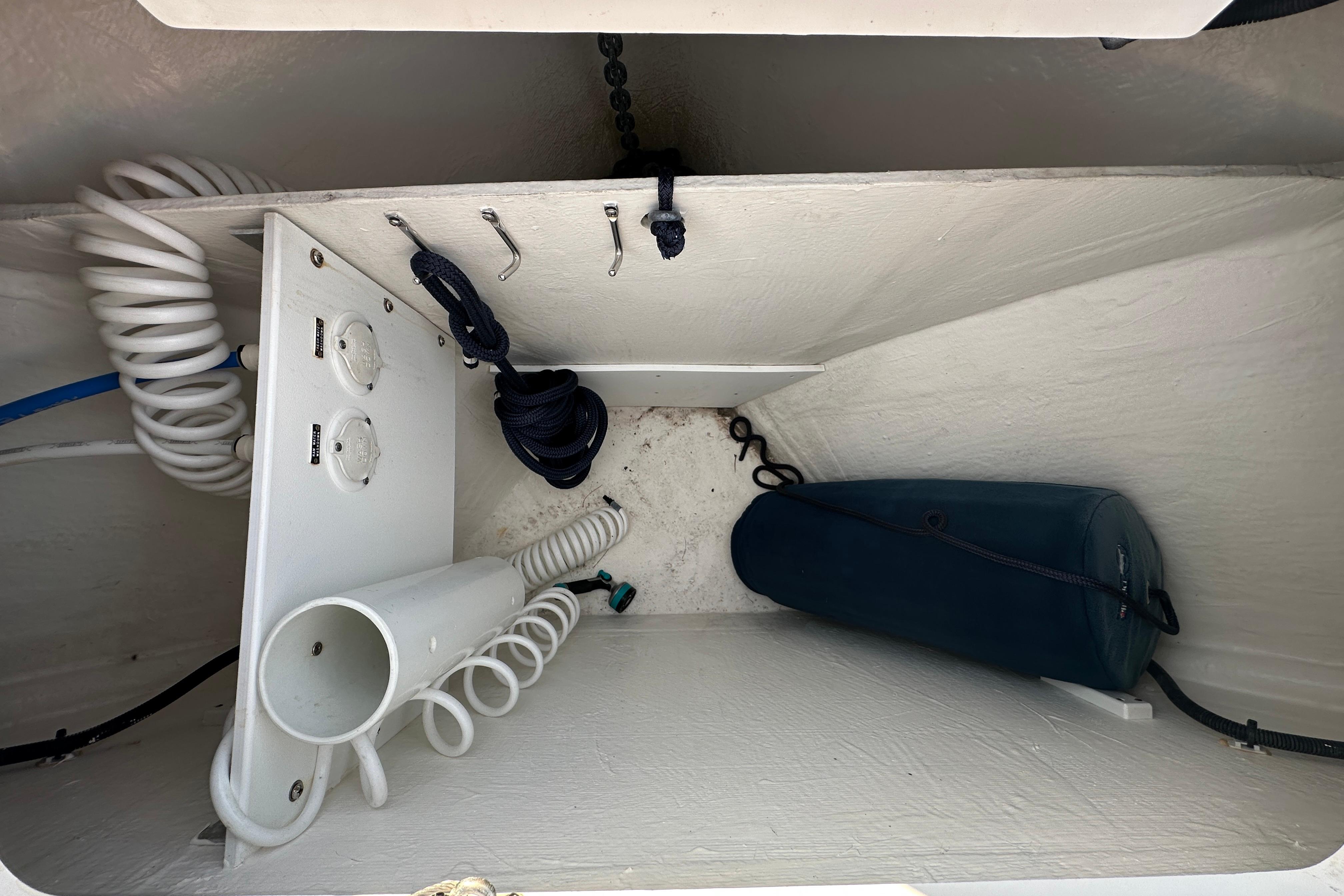 Storage compartment of a 2020 Back Cove 37 boat with coiled hoses and equipment.