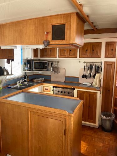 1977 Grand Alaskan Raised Pilothouse kitchen with wooden cabinets and modern appliances.