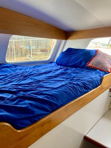 Cozy cabin bed in 1977 Grand Alaskan Raised Pilothouse with blue bedding.