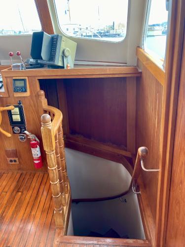 1977 Grand Alaskan Raised Pilothouse interior with wooden stairs and nautical equipment.