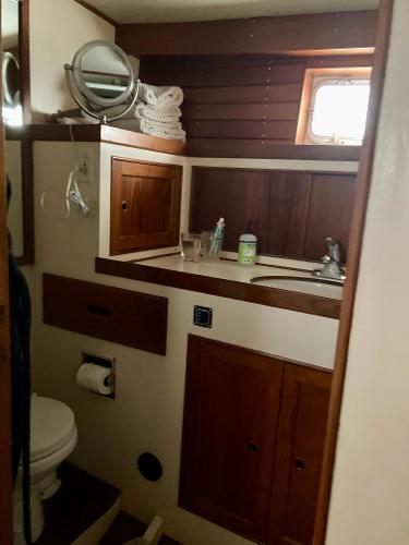 1977 Grand Alaskan Raised Pilothouse bathroom with wooden cabinets and nautical decor.