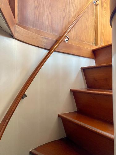 Wooden staircase inside 1977 Grand Alaskan Raised Pilothouse yacht.