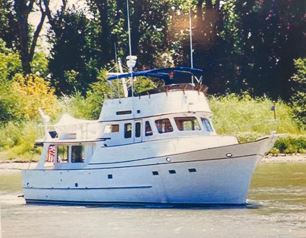 1977 Grand Alaskan Raised Pilothouse yacht cruising on a river.