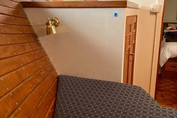 1977 Grand Alaskan Raised Pilothouse interior with wooden paneling and cushioned seating.