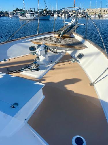 1977 Grand Alaskan Raised Pilothouse yacht deck with anchor, docked in marina.