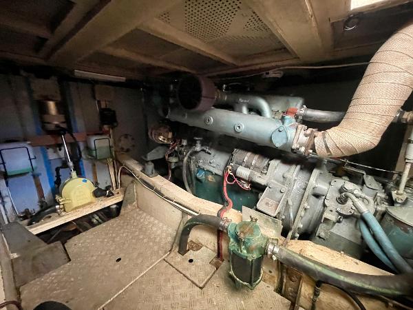 Engine room of 1977 Grand Alaskan Raised Pilothouse with visible machinery and pipes.