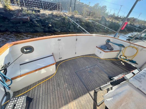 1977 Grand Alaskan Raised Pilothouse boat deck with wooden flooring and nautical equipment.