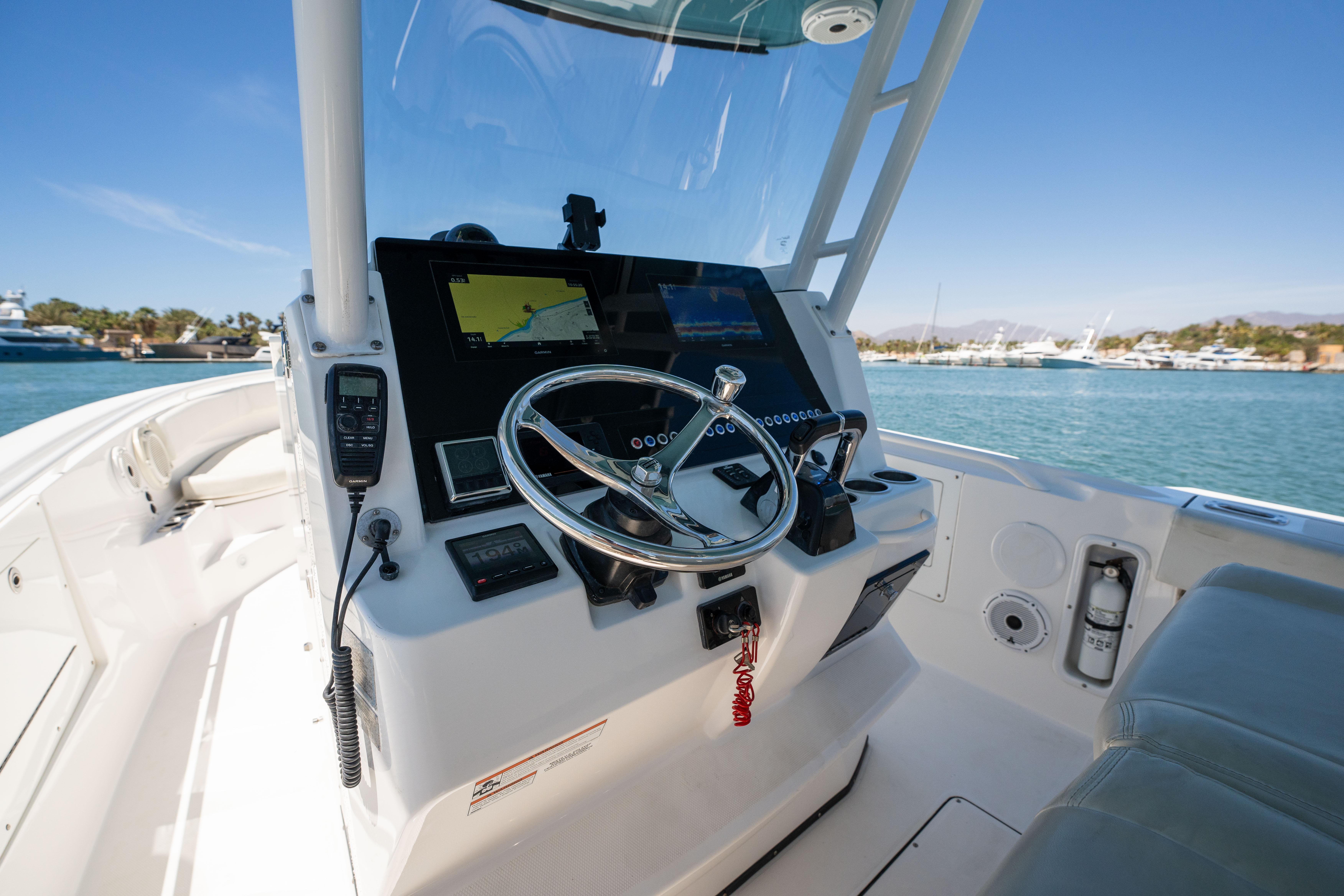 Edgewater-320CC 2020-Carnal CA-US-Edgewater 320CC 2020 boat cockpit with steering wheel and navigation equipment, docked by the water.-9821525 | Thumbnail